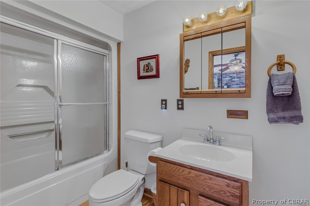 Full bathroom with vanity, toilet, and combined bath / shower with glass door