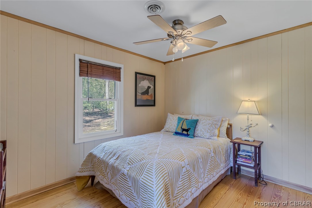 Bedroom featuring ornamental molding, ceiling fan, and hardwood / wood-style floors