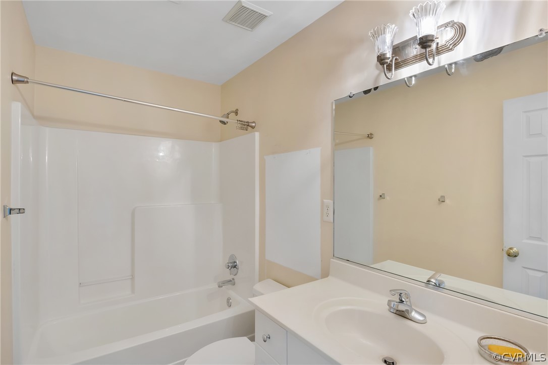 Full bathroom with toilet, vanity, and shower / bathtub combination