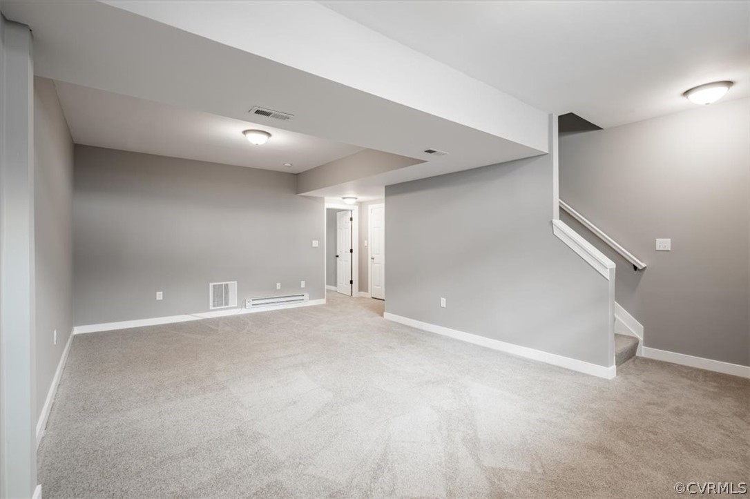 Basement featuring carpet flooring and a baseboard radiator
