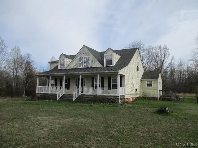 View of front of property with a front yard and a porch