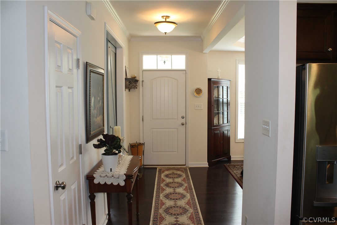 Entryway featuring crown molding and dark hardwood / wood-style flooring