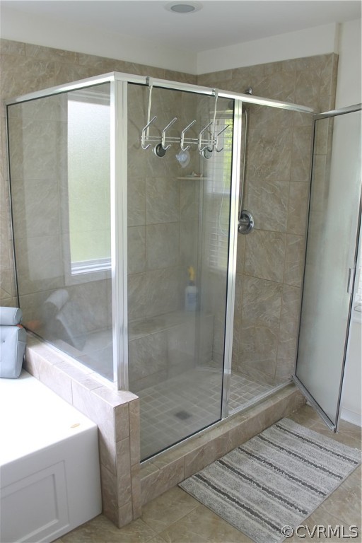 Owners bath with tile flooring and shower with separate bathtub