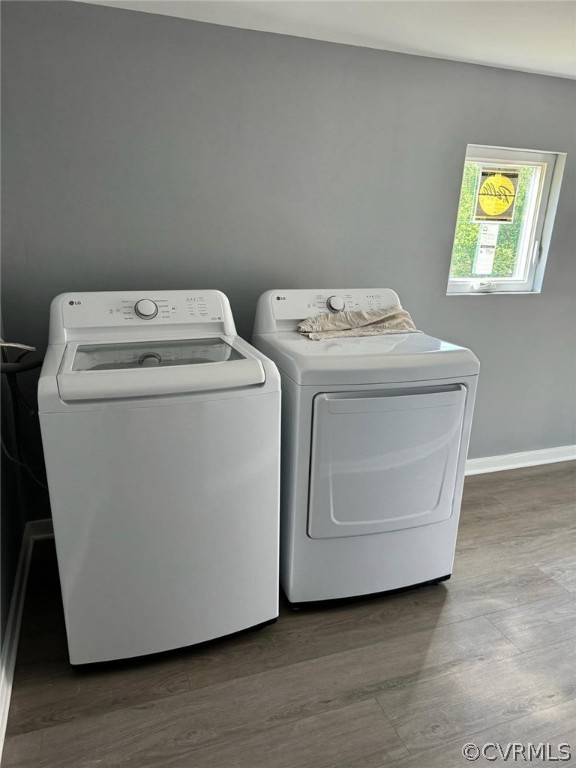 Clothes washing area with washer and clothes dryer and wood-type flooring