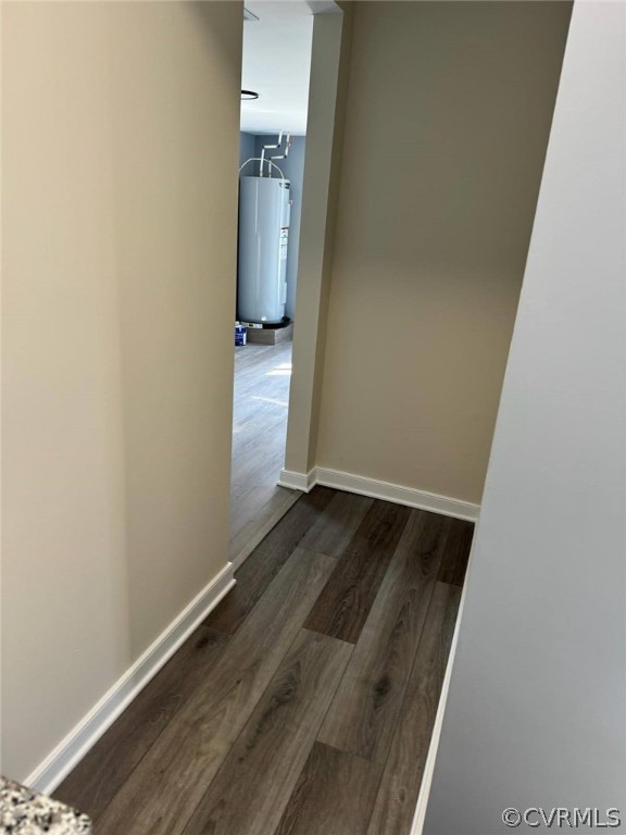 Corridor with water heater and dark hardwood / wood-style floors