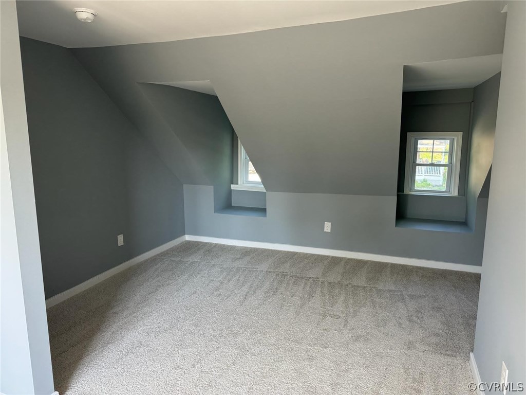 Bonus room featuring vaulted ceiling and carpet floors