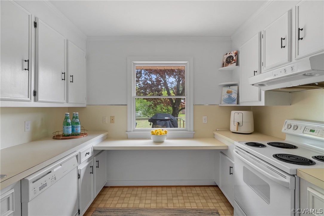 Kitchen featuring white appliances, light tile flooring, white cabinetry, and crown molding
