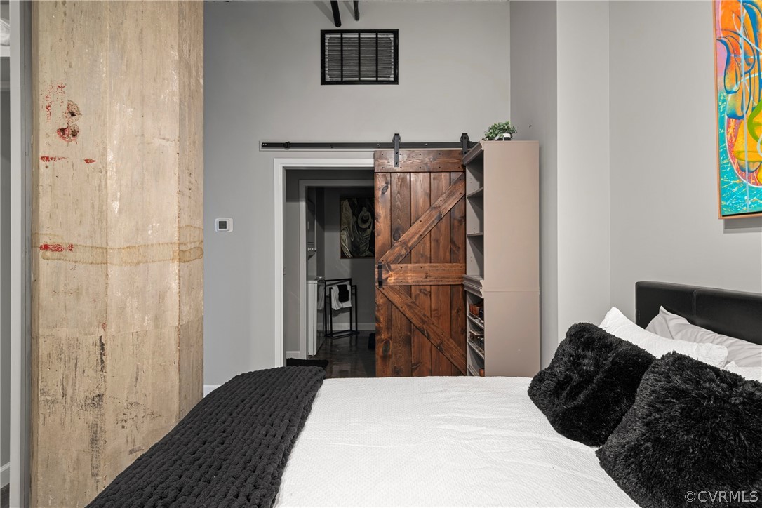 Bedroom with wood-type flooring and a barn door