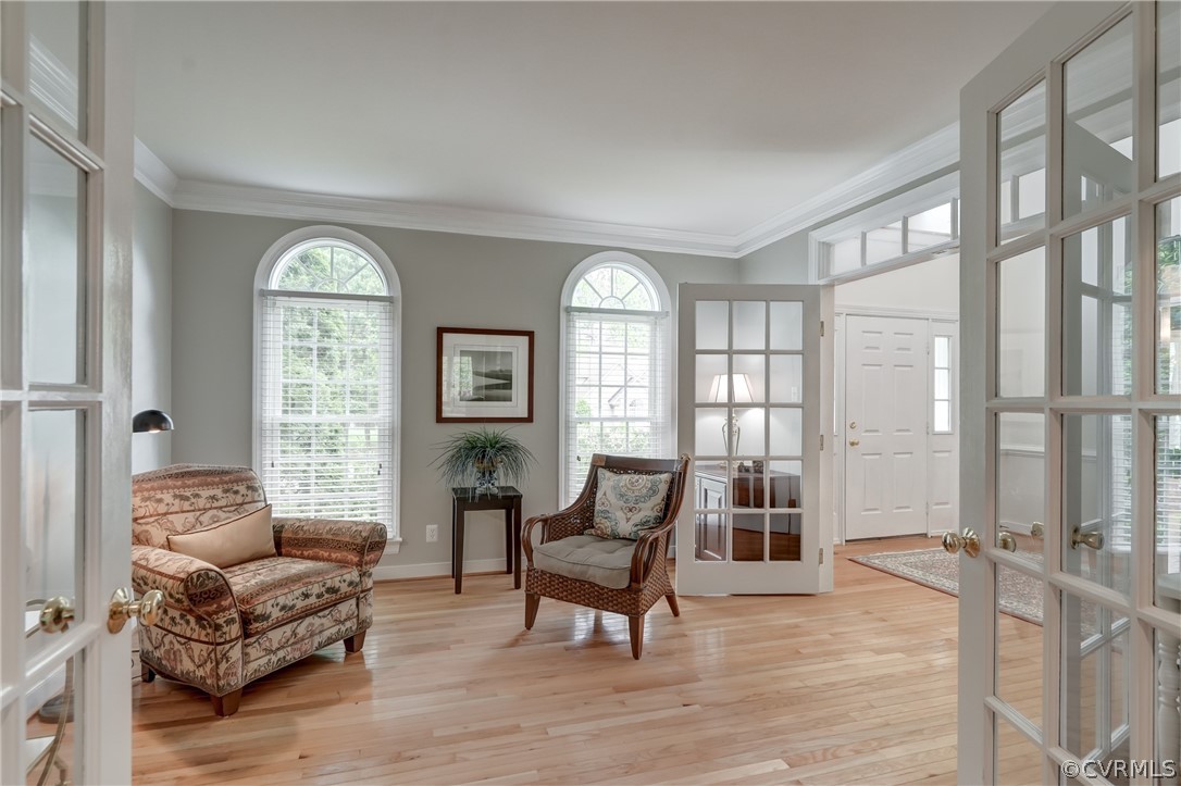 Living area featuring a wealth of natural light, ornamental molding, french doors, and  hard wood