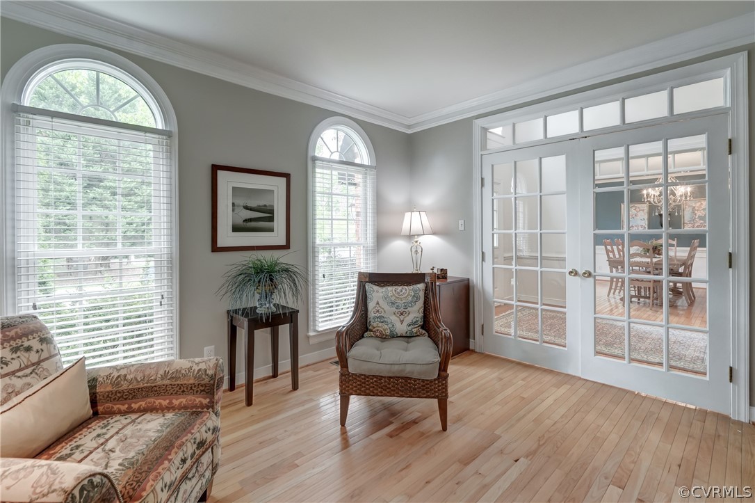 Sitting room featuring french doors, a healthy amount of sunlight, crown molding, an d hard  wood flooring