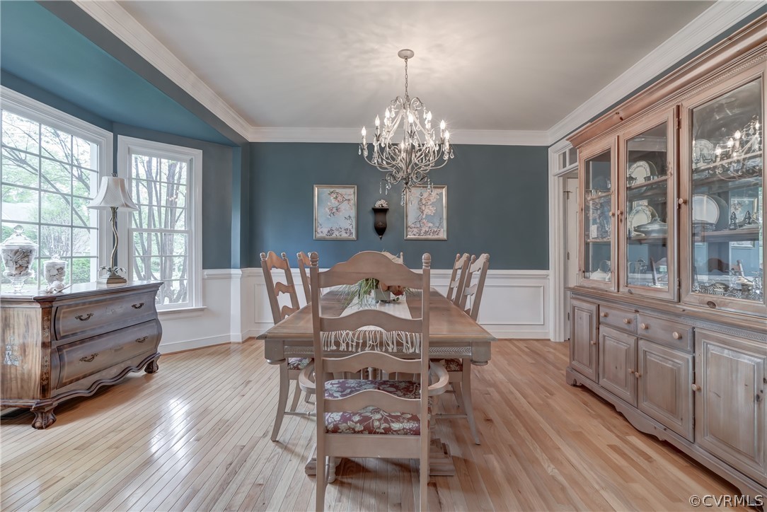 Dining room featuring ornamental molding, a chandelier, and hardwood flooring