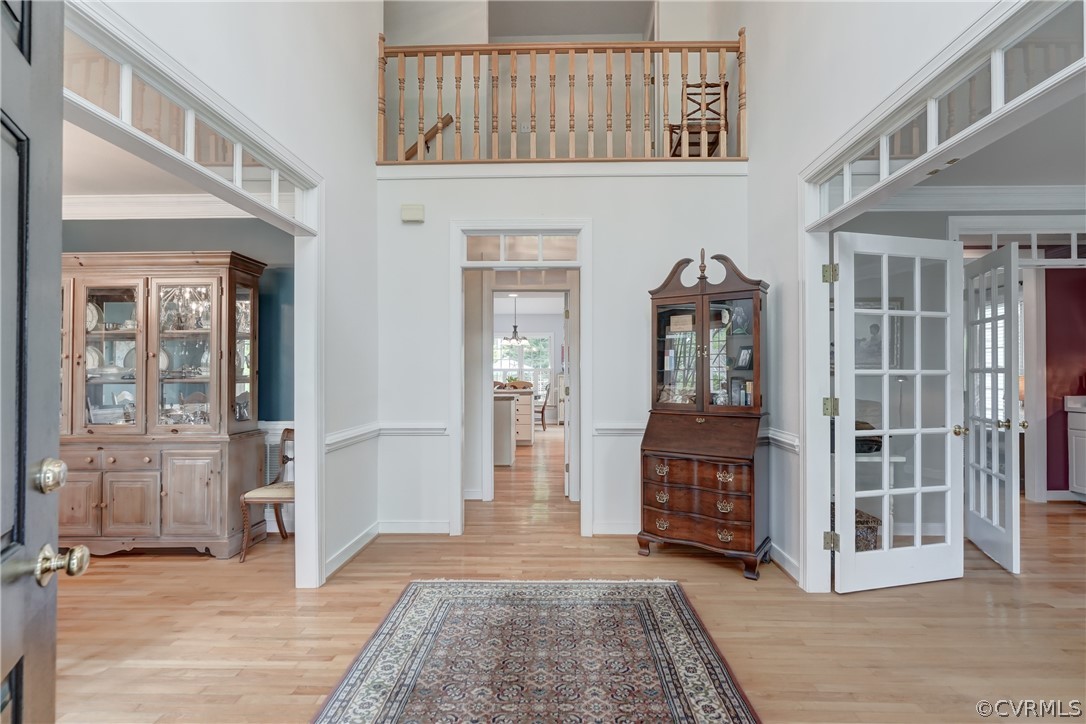 Entryway featuring french doors, light hardwood flooring, and ornamental molding