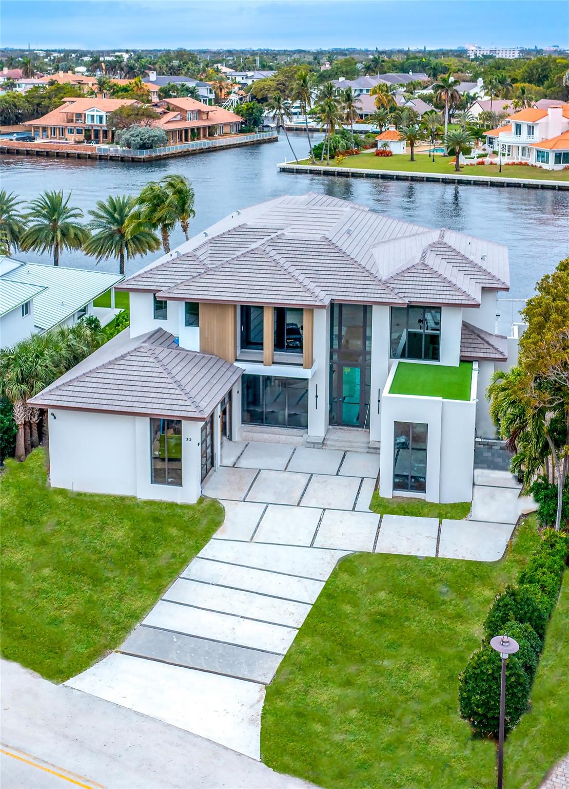 This Intracoastal estate in prestigious Sea Ranch Lakes is a masterpiece of ultra-luxe design. Gated w/its own police force, private Beach Club & private beach access. Developed by Beth Geduld Holdings, this extraordinary 9200 total sq ft home integrates indoor/outdoor living w/sliding glass walls, east & west light filled views, intracoastal breezes & expansive balconies. This turnkey home w/110’ of waterfront features elegant millwork, multiple entertaining/dining areas, 500 bottle wine display, infinity pool, outdoor cabana. Primary bedroom features separate bathrooms & an outdoor shower on terrace. Additional features include elevator, clubroom, 3-car garage, boat dock, generator ready & lush landscaping. Located minutes from prestigious Pine Crest School. Expected completion 2/25.