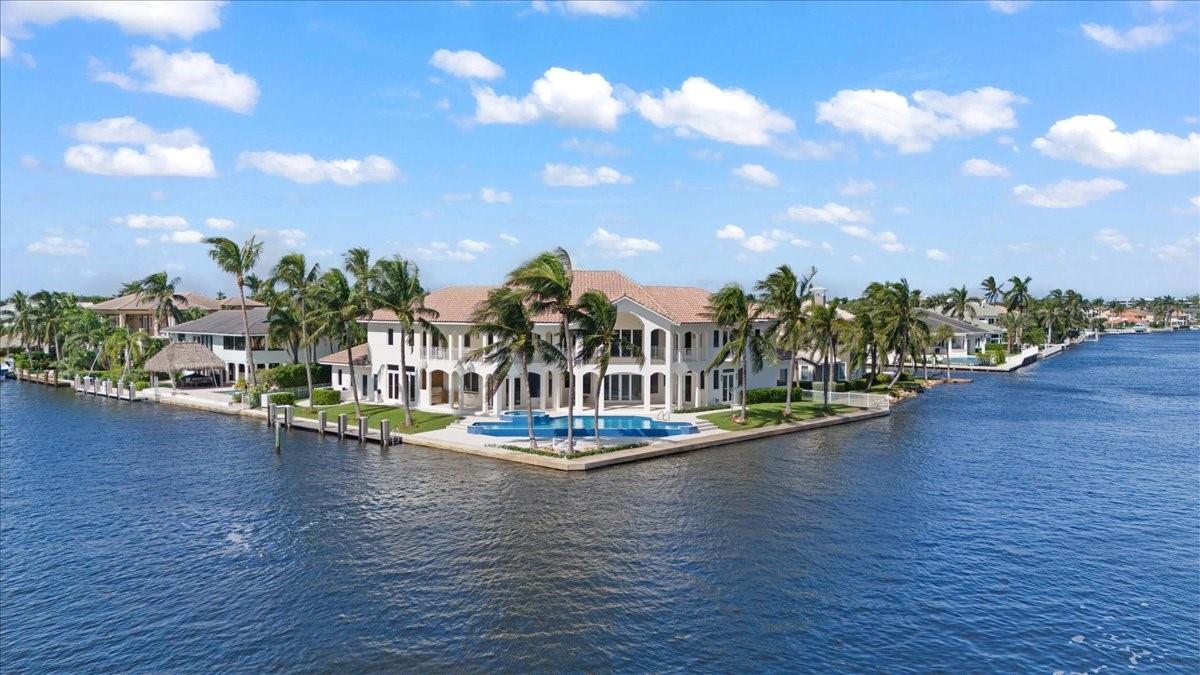 Discover the epitome of waterfront living at 978 Dogwood Dr, Delray Beach. This stunning point-lot estate offers over 250 feet of water frontage, complemented by timeless charm and modern conveniences. With an open layout and soaring ceilings, the home features 5 bedrooms and 9 baths, each with an en suite. Enjoy water views from every room and dual master suites—one on the first floor and one upstairs. An entertainer’s and boater’s dream, it accommodates a 125-foot boat with direct Intracoastal access and a walk-in wine room for connoisseurs. Solid concrete construction with a concrete subfloor on the second level ensures lasting durability. The coveted southern exposure enhances natural light and outdoor living. Located in Tropic Isle, this is luxury waterfront living at its finest.