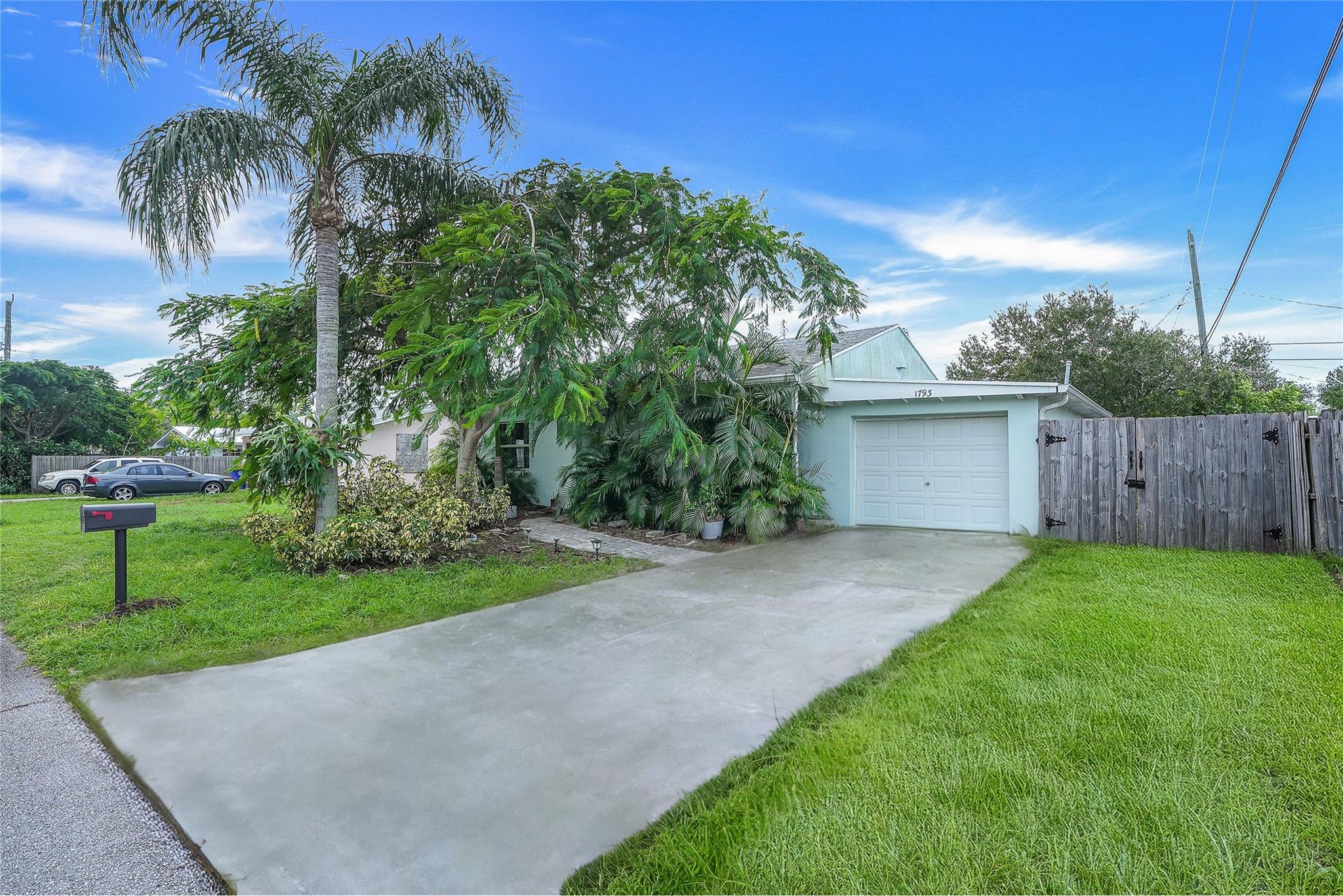 In the heart of Jensen Beach, this inviting home welcomes you with open-concept living at its best. The spacious great room flows into a kitchen designed for both functionality and style, with plenty of counter space to make cooking a breeze. The dining area leads to an enclosed season room, where tile floors and bright natural light create a perfect spot to relax. Outside, the large yard is a canvas for outdoor living, ready for family gatherings or quiet mornings. A bathroom with a walk-in shower completes this home, offering both comfort and convenience in every detail. Your Florida story begins here.