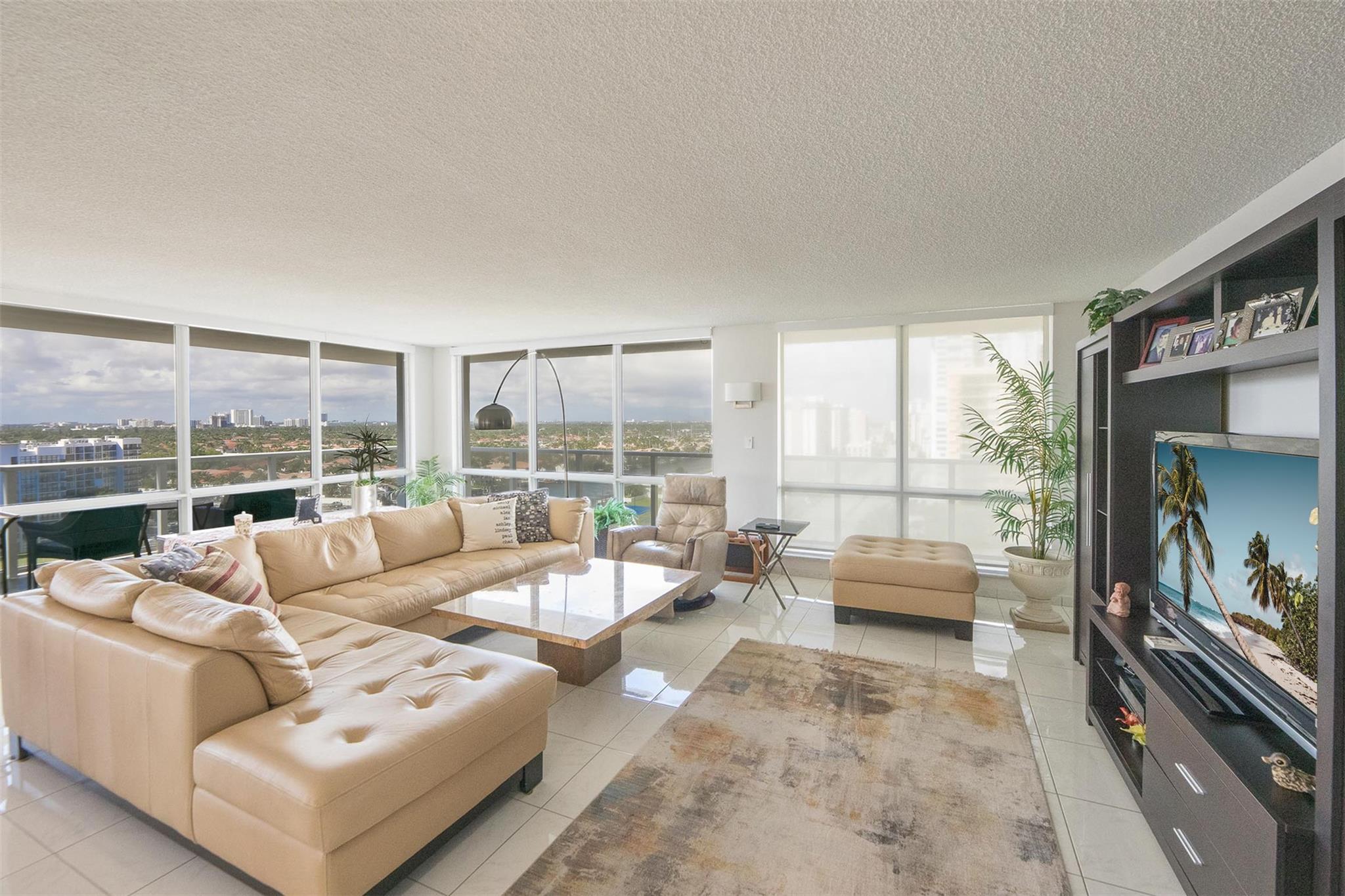 Experience the pinnacle of luxurious beachfront living! This updated corner unit boasts an ideal location with breathtaking west-facing views of the city, the Intracoastal, and stunning sunsets. Inside, enjoy a spacious layout featuring a wrap-around balcony, impact floor-to-ceiling windows, and the added convenience of an in-unit washer and dryer. The expansive living room, filled with natural light and panoramic views, is perfect for relaxation or entertaining. The building offers exceptional amenities, including a gym, two pools, an on-site restaurant, valet service, and full beach service.