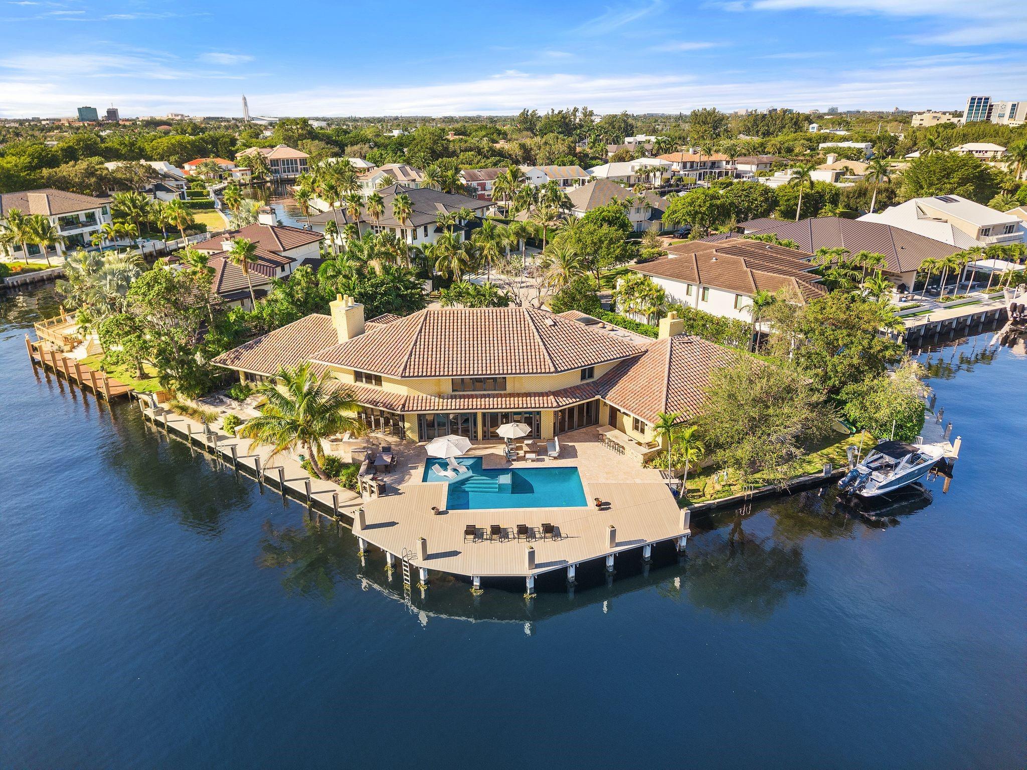 Welcome to this spectacular point lot estate located in the prestigious, private gated community of Bay Colony.  A yachter’s dream boasting 240’ of waterfrontage, boat lift, wide canal and turning basis, this home can accommodate multiple yachts or catamarans.  It is a perfect family home spanning over 7,300 sq. ft. with 5 beds and 7 baths and is located in close proximity to the premier private schools of Pine Crest School, Cardinal Gibbons and Westminster Academy. Primary suite encompasses the entire second story with sauna, private office, and separate sitting room. Enjoy the expansive water views from the renovated heated, saltwater pool and patio area that includes a built in summer kitchen.  On just over 1/3 of an acre this is arguably one of the best lots in all of Fort Lauderdale