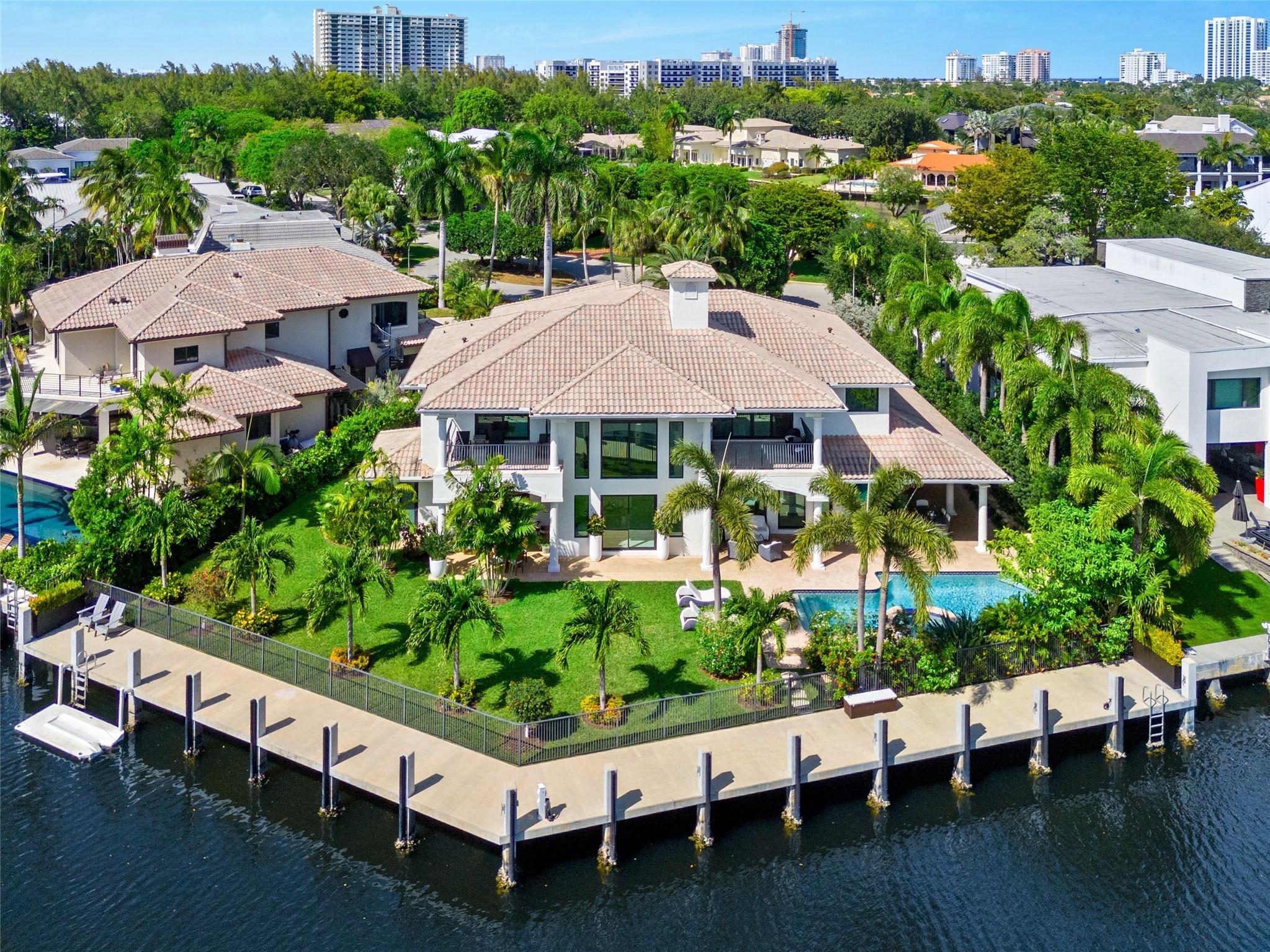 Welcome to timeless elegance in Bay Colony, Fort Lauderdale’s notorious 24-hour guard-gated community. Set on 140 feet of deepwater frontage with no fixed bridges, this estate offers yacht accommodations, a new extra wide concrete dock and a raised seawall. The backyard boasts of an outdoor kitchen, heated pool, covered entertaining space and an expansive outdoor retreat. Step inside and be greeted by soaring ceilings, a sun-drenched open floor plan and a chef’s kitchen adorned with subzero appliances, and refined finishes throughout. The primary suite features both his and her baths and closets, a private office, and gas fireplace. Enjoy close proximity to Pine Crest School, Coral Ridge CC, an executive airport, and the beach.