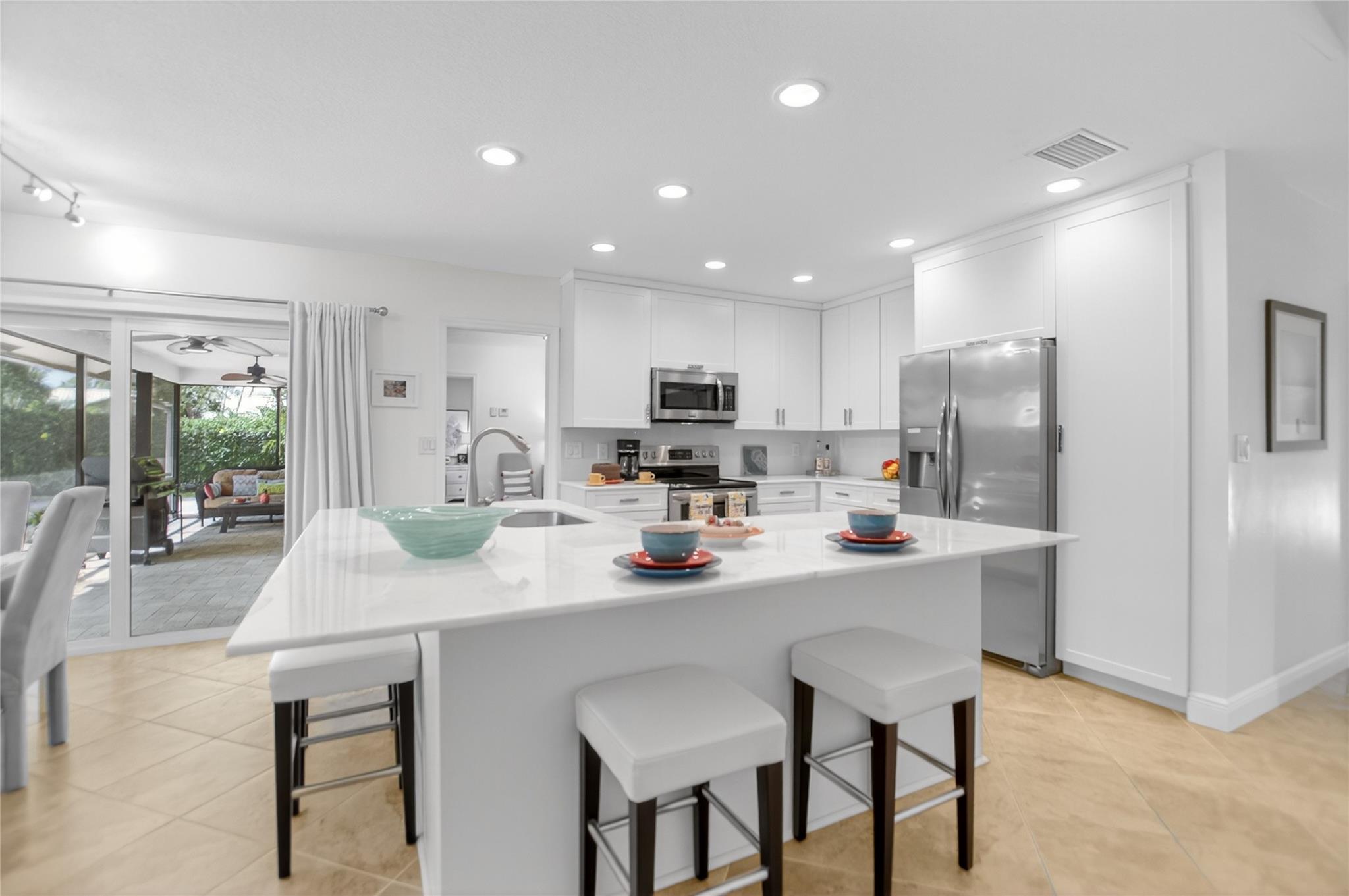 CONTEMPORARY POOL home in WOODLAKE! 4/2.5 UPDATED W/ 2,700+ sf & NEW ROOF! Double door opens to CONSISTENT ceramic tile flooring in all LA. LR has a bay window w/ Plantation shutters! Big DR opens to the covered patio. CHEF’S kitchen w/ island & MARBLE counters. NEWER S/S appliances & 42” cabinets. Farmhouse sink, big pantry &  full marble backsplash. Enjoy movie night in the FR w/ soaring ceiling & fireplace. Fall in love in BIG primary suite w/ a slider access the pool & patio. HUGE walk-in closet w/ build outs!  NEWER primary bath w/ shower has Saturnia & double vanity. Big corner BR2 w/walk in closet. Guest bath w/ a frameless shower & vanity.  BR 3 is big. BR 4/office has bamboo flooring. Inside laundry w/ Maytag W/D. HEATED pool w/extended travertine pavers. Large, screened patio!