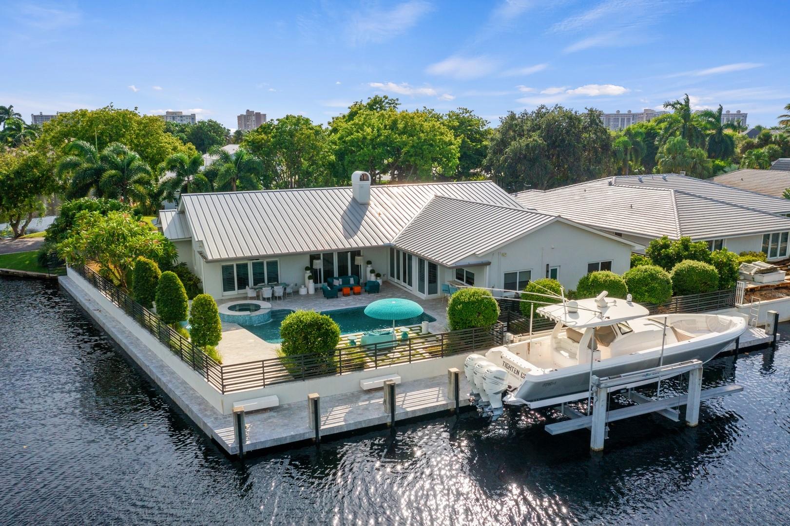 This elegant California style transitional residence is situated on an interior point lot with +/- 212FT of waterfront in the guard gated community of Bay Colony. Bay Colony is a 24 hour secured, patrolled community with spectacular treelined streets. Completely renovated in 2018, this 4 Bedroom, 4 bathroom single story residence features a foyer entrance, generous master suite, formal living and dining areas as well as a more modern open floor plan for the family room, kitchen, breakfast and wraparound bar, all with pool and waterfront views. Well appointed guest rooms feature stunningly finished en-suites. The waterfront salt chlorinated and heated pool with spa sits on the gorgeous landscaped patio overlooking the water and +/- 92FT dock with boat lift.