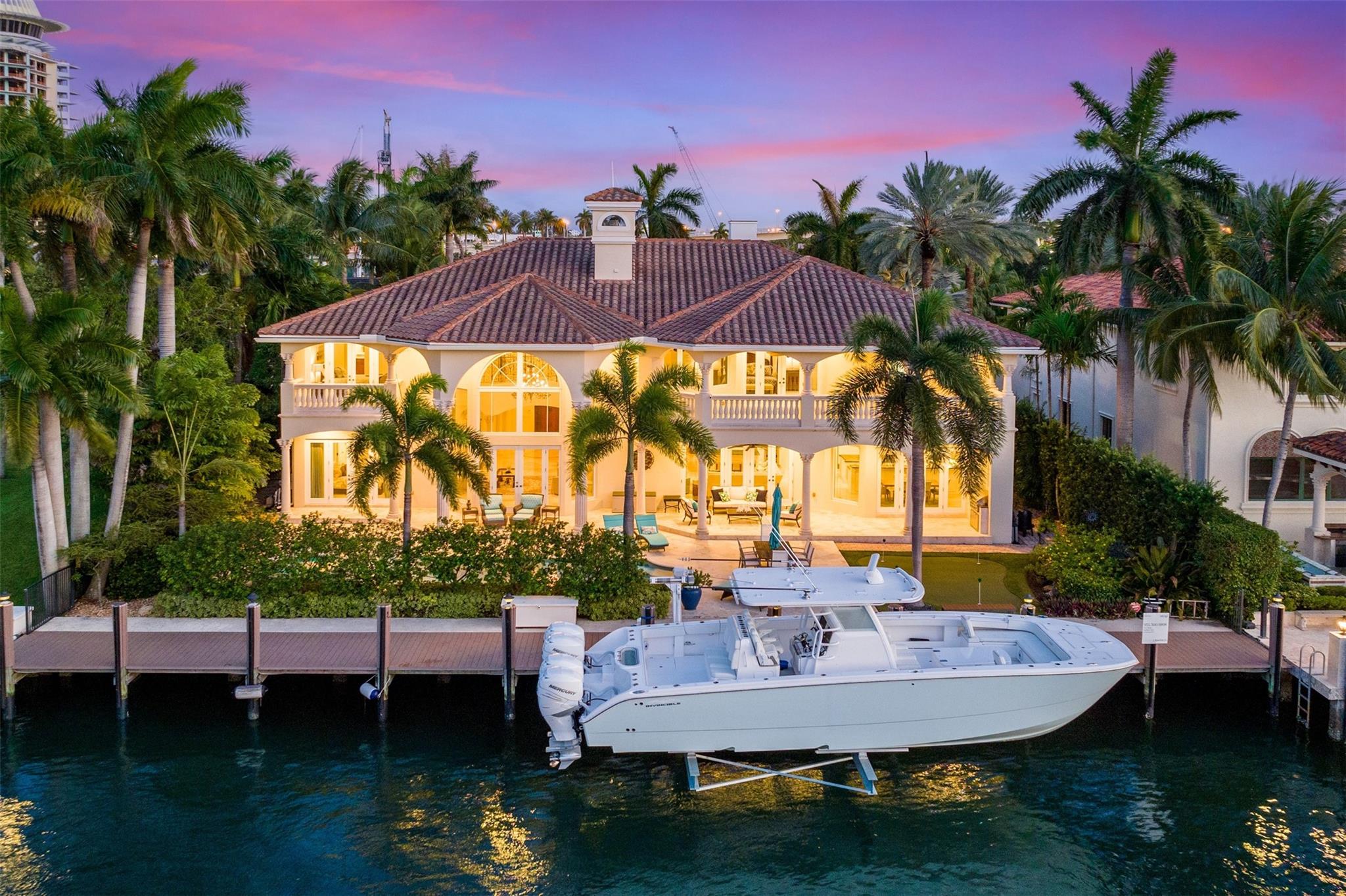 Introducing an exquisite waterfront estate nestled in the prestigious Harbor Beach gated community. This 7 bed/7.5 bath home situated just 4 homes from the Intracoastal w/ 100' WF offers quick ocean access. Inside, find a Great room w/ soaring ceilings & a grand fireplace. Updated chef's kitchen & bar seamlessly connects to family room. VIP Suite on 1st floor, oversized Primary suite, 2 junior suites + 2 en suite guest rooms provide ample accommodations. Additional office & gym. Outside, find a covered patio w/ BBQ, heated pool, hot tub, & putting green. Recently installed 20Klb lift, new dock, upgraded AC's, & new wood flooring throughout. Private HB Beach Club membership available. Just minutes away from the beach, dining, & FTL airport. Experience the epitome of waterfront living!