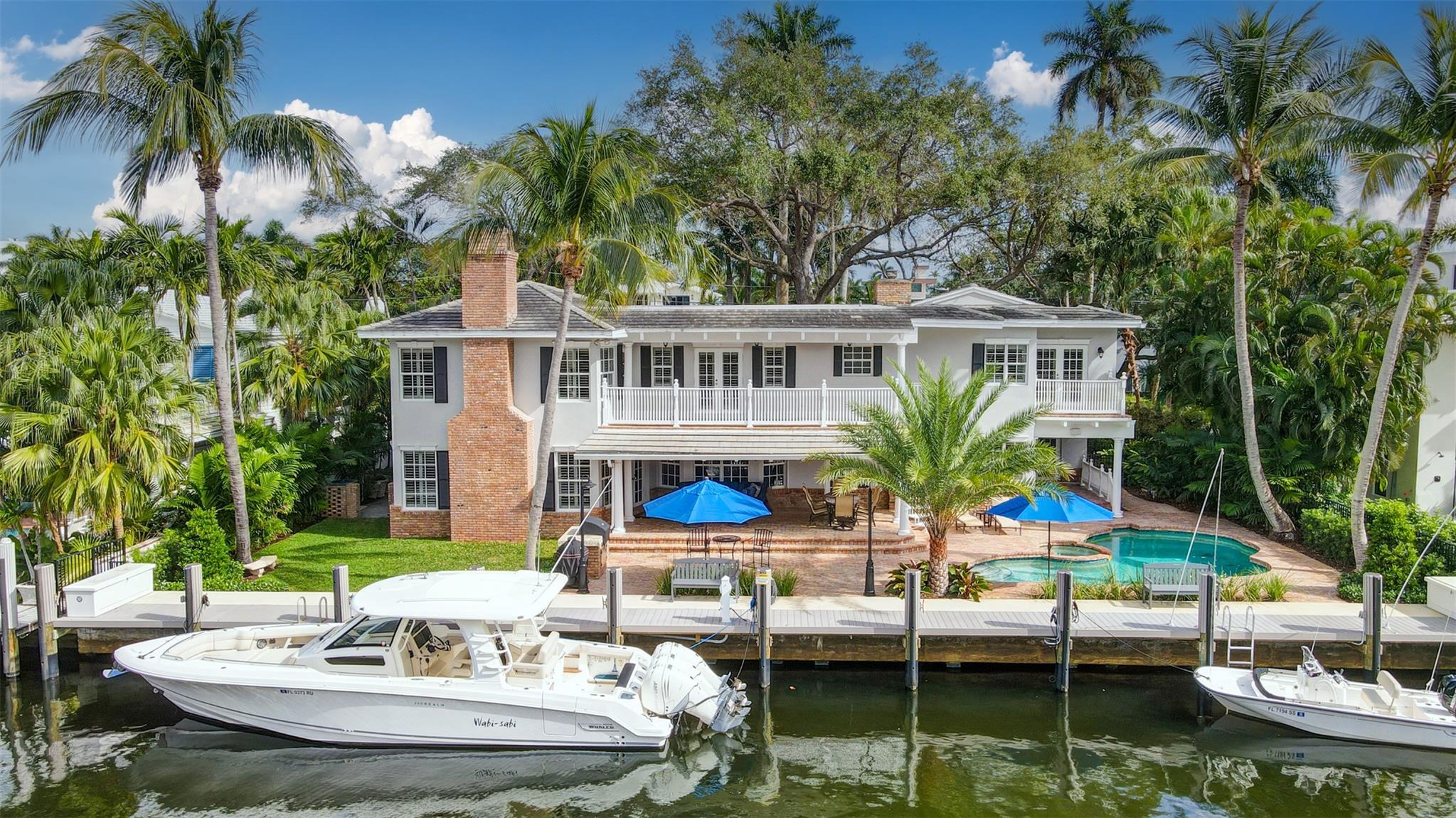 Currently the very best-priced deepwater Las Olas Isles home per sf on 100ft of waterfrontage! Ideal for boaters. Offering a new 2022 seawall cap, dock & 100 amp service. New roof in 2018. Spacious living areas flow effortlessly with pool/canal & distant New River views. Oak wood floors & fireplaces. 1st floor: Formal living & dining, great room, breakfast area, open kitchen, bar/butler's pantry & utility room, additional media/family room, private 1st floor guest suite/cabana bath. 2nd level: flexible 5 bedrooms & home offices! Expansive primary suite occupies entire wing, includes bedroom, private sitting room & balcony + large home office. Situated on a secure, patrolled isle, newly paved street & underground utilities planned for 2024. Perfectly located for Las Olas & the beaches.