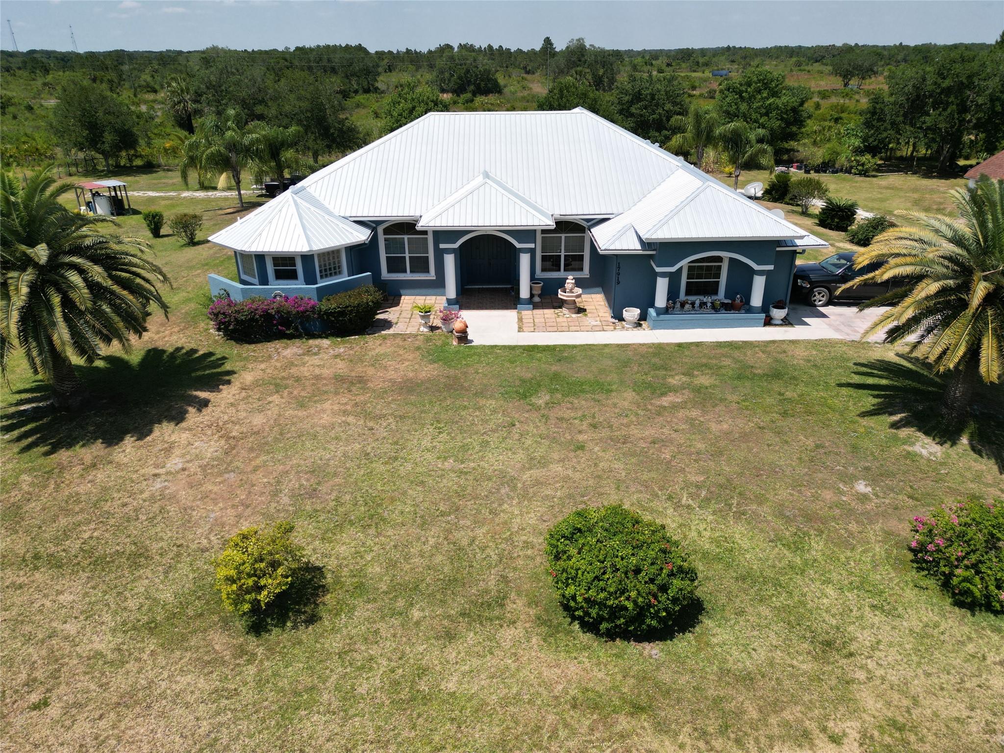 Beautiful Country Paradise! This manicured estate offers 3.75 Acres, fully fenced w/ 3 bedroom, 2.5 baths, 2 car garage, w/ 12 foot ceilings, office, great room, formal dining, morning nook, large kitchen with bar & ss applicances, granite tops, butlers pantry/mudroom, foyer, laundry rm, formal living room, master suite w/ tray ceilings, large tub, huge walkin shower, his & hers closets, large covered patio for entertaining. Outdoors you'll enjoy mature trees, park benches through out the property, and a large gazebo for relaxing & enjoying the outdoors! Sale includes a NEW METAL ROOF, 3 yr AC, & WH. chicken coops, small barn, hand pump on well, water system, washer & dryer.  This is a serene and calming life! Gorgeous sunsets, wildlife in abundance, animals & farming & plenty of privacy! Near the Kissimmee Prairie State Park, offering many nature related activities! Also available for sale is an additional adjoining 1.25 acre parcel for $45,000. Enjoy a total of 5 ACRES!