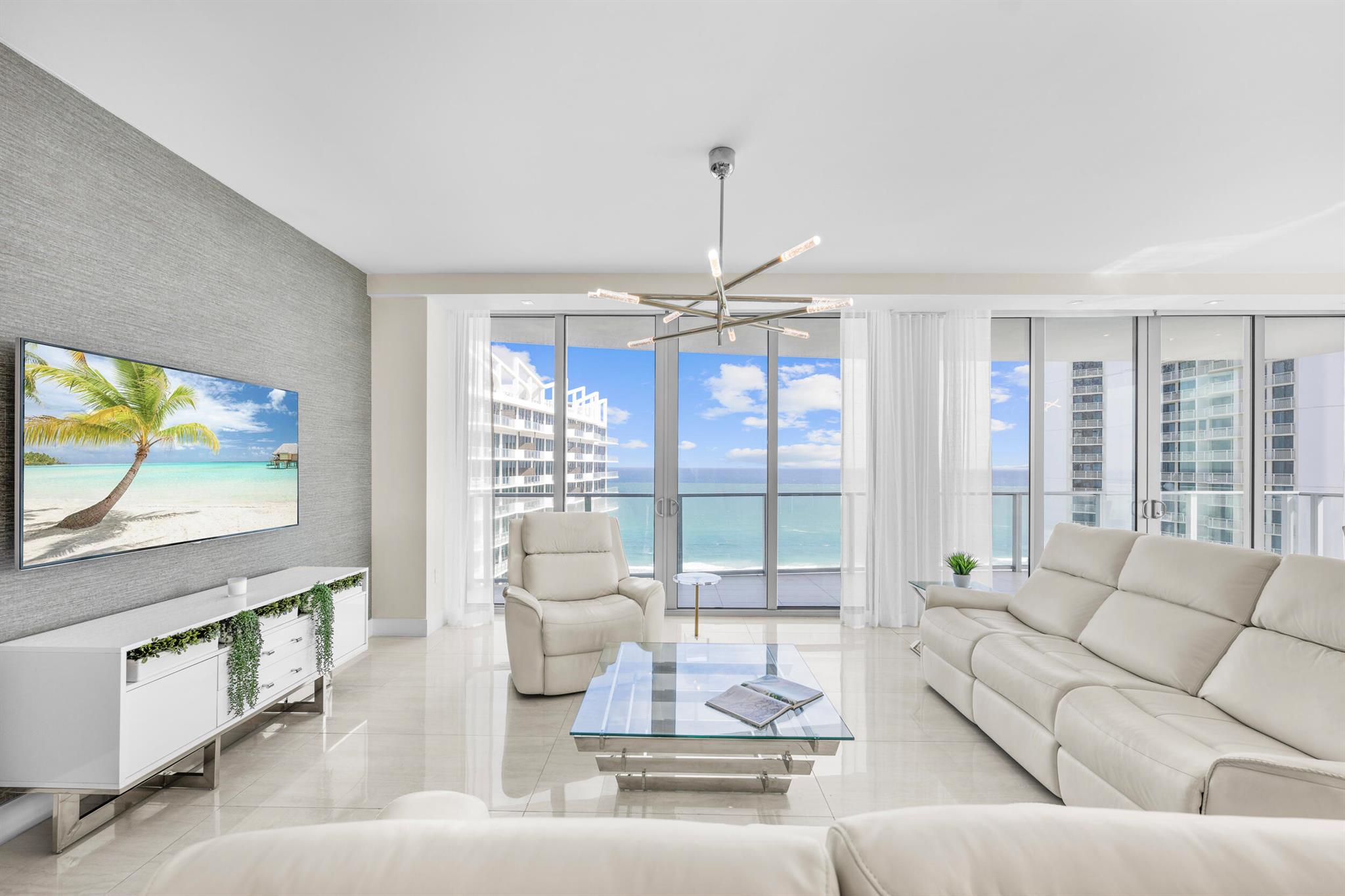 A rare opportunity to acquire a fully furnished and turn key beachfront 2023 built newer construction residence. This residence commands the entire southeastern section of the newly built Peace Tower, offering unparalleled ocean and intracoastal views from the 18th floor. Take in unobstructed water views from every room, sunrise to sunset. At 3,425 total square feet with 2 Bedrooms, 1 Den/Office, 2.1 Baths, wet bar and a laundry room, 1805P is one of the largest offerings available at Amrit Ocean. The expertly designed layout features 2 intracoastal view bedrooms and a spacious den/office which could easily be converted to a 3rd bedroom with the simple addition of a door. Each bedroom has balcony access and floor to ceiling sliding glass doors overlooking the island. The primary suite features custom walk in closet as well as a modern spa-like bathroom with a soaker tub, separate shower, dual sink vanity, and chic frosted glass encased water closet. Both guest bathrooms feature elegant modern designs, and all closest have been custom built with after market upgrades from JL Closets. The open concept living spaces include a gourmet kitchen, formal dining space, living room and a wet bar, all overlooking unobstructed ocean views. The tastefully appointed kitchen comes equipped with Miele appliances, custom cabinetry, quartz countertops,  and an oversized eat-in island with bar seating. The additional wet bar with wine cooler and custom cabinetry further enhance the gourmet offerings of this residence. Additional features include a dual zone ADT home security system, a Savant Home System, and custom blinds to be installed February 2024. 

Move in to brand new construction completed October of 2023 without any effort to install closets, select lighting, move in furniture or select finishes. The property comes equipped with a plethora of custom upgrades, designer elements, and all furniture is included for an effortlessly smooth transition into the Singer Island lifestyle. Amrit is one of the ONLY beachfront condominiums that allow immediate nightly rentals, annual leases, seasonal leases and short term rental stays making it a rare opportunity for investors, or owners who would like to utilize the property as an investment while they are away. Situated on 300 feet of pristine beach frontage with 24 hour valet, dog runs, and more Amrit combines the best of luxury waterfront living with modern 2023 new construction. Residence 1805 is located in the newly completed Peace Tower of Amrit Ocean Resort and Residences. The sister Happiness Tower is currently in development, slated to feature fine dining on property including offerings like their exclusive Ayre restaurant, a resort restaurant and a beach bar. The projected future wellness plans include integrated health offerings, hydrothermal experiences and a salt inhalation chamber per the Amrit Resort Spa website. Residence 1805 offers the unique opportunity to get into a newly built section of this development and watch as the remaining aspects of the Happiness Tower's hotel, restaurants and amenities are brought to life by the development team.