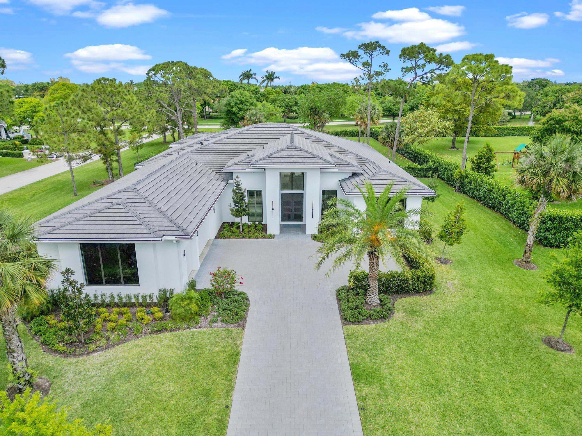 Built in 2023, this 5-bedroom, 5.1-bath custom estate sits on a 1+ acre corner lot in the gated luxury community of Steeplechase in Palm Beach Gardens. The home features an open foyer and spacious living area with 10-foot sliding doors that lead to a backyard with a heated saltwater pool w/ jacuzzi, summer kitchen / grill area, and cabana bathroom. The primary suite features a spacious bedroom overlooking the backyard, his-and-hers walk-in closets, dual bathrooms with separate sinks, and luxurious amenities, including a freestanding tub and a spa shower. Each guest room has an en-suite bathroom and ample closet space, and a 6th bonus room offers flexibility for a gym, office, or playroom. 24x48 imported porcelain tile flooring throughout. The chef's kitchen is equipped with