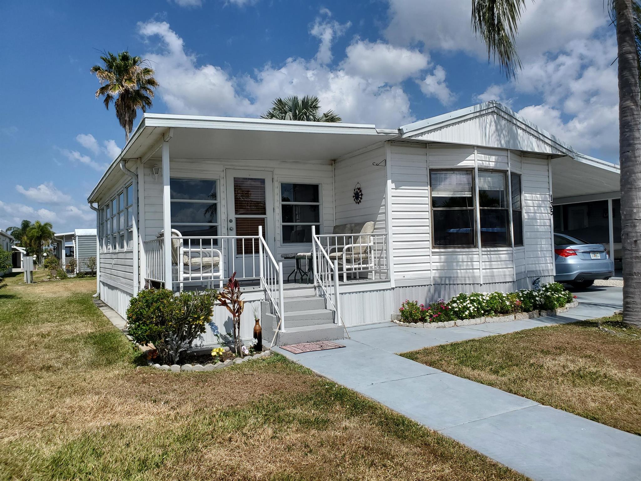 Enjoy your retirement in this 2 bedroom 2 bath home with a spacious Florida room. The covered  2 car carport has a workshop attached for added storage.  Oasis Village is an active 55+ community with a heated pool, pickleball, shuffleboard, billiards, and a nice clubhouse for your social events. Convenient location near shopping centers and Lake Okeechobee.