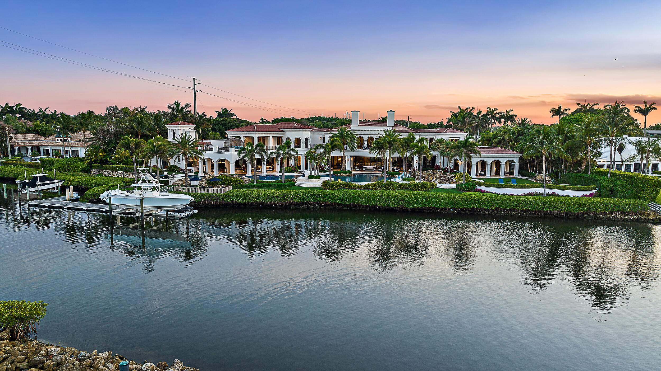 Ultimate Trophy Property in Admirals Cove. Nestled within the exclusive Admirals Cove community, the home originally completed in 2016 has just undergone a $12 million+ total remodel and addition, completed in 2023. This magnificent trophy property offers unparalleled luxury and coastal living. This amazing estate can never be built again in Jupiter due to its size. Priced $9 million below 2024 appraised value and $40 million below replacement cost, which today would be in excess of $85 million.  This offering provides a truly unique opportunity that literally can't be recreated today at any cost. This property spans nearly 1.5 acres of prime, protected waterfront with over 365 feet of Intracoastal waterfrontage and can accommodate a Mega Yacht, with views of the Waterway and beyond. The expansive pool, which cost in excess of $1.5 million, invites relaxation, complete with two hot tubs for ultimate indulgence, a pedestrian bridge that crosses the pool with cascading waterfalls, fire bowls, swim up bar, two summer kitchens, and drop-down TV all with unparalleled 180 degree views of the Intracoastal and across to a park and beautiful white sandy beach preserve that will not be built on. The multiple loggia seating areas provide shade and comfort all year long. Toy lover? This property has a showroom garage that will hold a 45' motorcoach and 18 plus cars with marble flooring, air compressor system, three double car lifts, several storage and work spaces, restroom and laundry room, perfect for the car enthusiast. Primary palatial suite with expansive views of the resort style pool and waterways. Offering separate his and her bathrooms and closets, the sleek and clean her bath, complete with water room with large infinity edge soaker bathtub with underwater LED lighting, large steam shower, hair salon with wash station that opens up to a boutique style closet with hidden washer and dryer.  Masculine his bath and closet has a custom glass tile and marble shower, opening to a closet fit for a king overlooking fountains and waterfalls that flow into the pool as well as a hidden washer and dryer. 5 large secondary guest suites having private baths, balconies and sweeping Intracoastal views. Entertainment areas galore with custom bar, sports lounge room with 5 TVs for the ultimate game day experience, arcade and game room with golf simulator, multiple TV's, shuffleboard and a home theater, that cost over $1 million, was designed for the ultimate movie night.  The quality level and craftsmanship of this home is just unimaginable, and it is Kemper Certified. This property has it all!! Buyers need to be verified for showings.