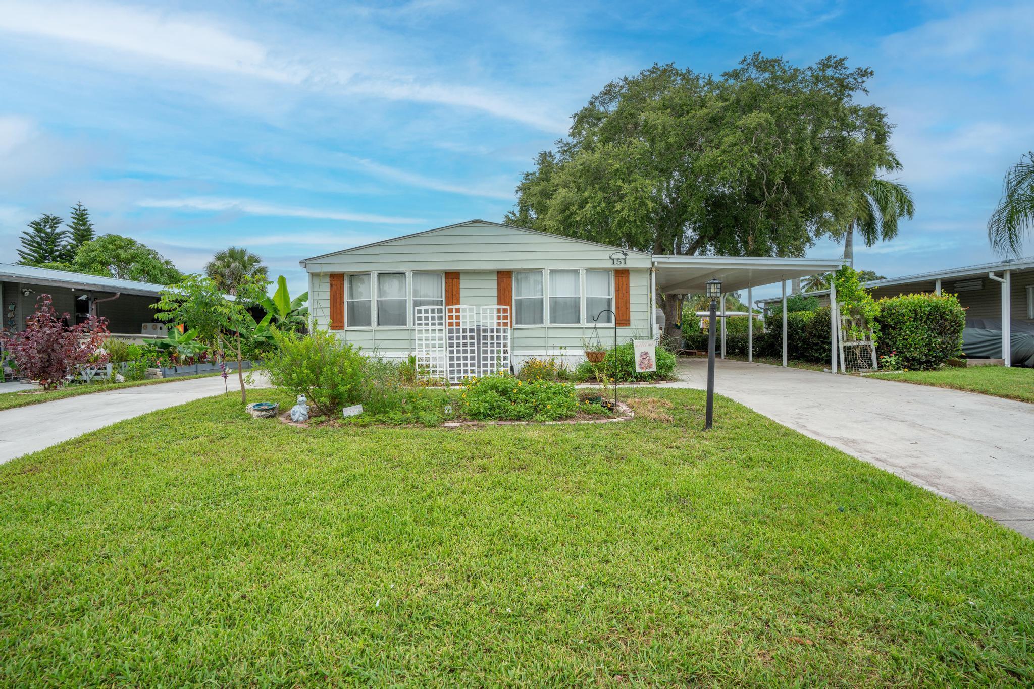 WHAT MORE COULD YOU WANT?!  OWN YOUR LAND & HAVE OCEAN ACCESS, Boat Lift, and Private Dock! This 3-bed, 2-bath manufactured home in Tropical Paradise features newer laminate floors throughout, fresh interior paint, a metal roof, and an AC unit from 2021. Enjoy nearby Halpatiokee and Atlantic Ridge parks, easy access to I-95, and convenient shopping. The property includes two driveways, a 1-car carport, a shed, and a rec lot for boat/RV storage (free) with water and electric. Abundant wildlife includes manatees, otters, stingrays, ducks, snook, and various fish. Don't miss this amazing location! Seller is open to offers!!!