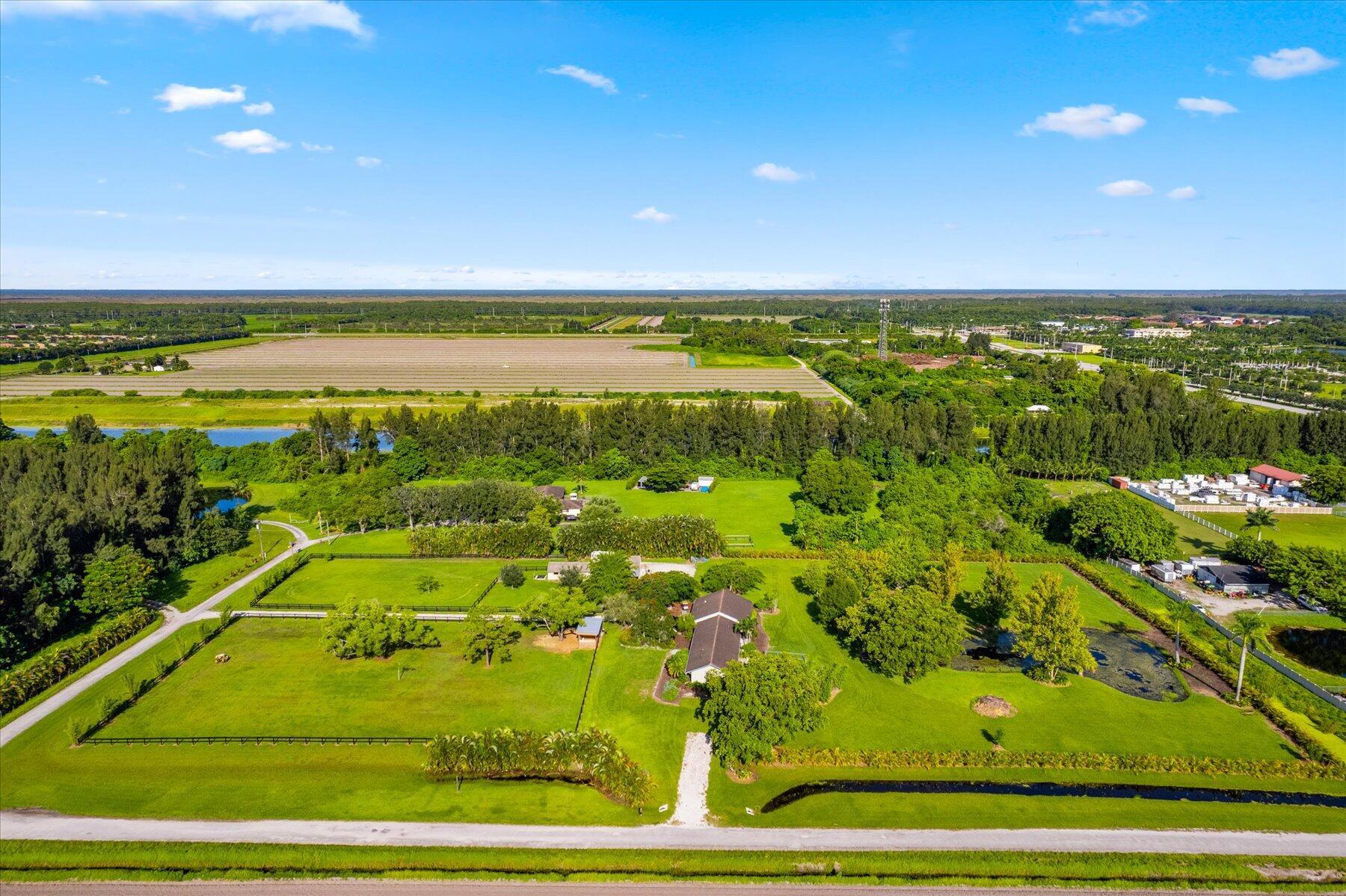 Beautifully landscaped 5 acre horse farm just off Boynton Beach Blvd. The farm features beautiful pasture and pond views. The recently updated 4 bedroom 3 bath home includes a mother in law or guest suite with panoramic views of the pool, pond and pastures.  For the horses, there are 5 stalls attached to a large equipment barn where there is plenty of room to store all your feed, equipment and machinery. There are also 2 newly constructed stalls in one of the large paddocks. RV hookup on site as well. Conveniently located just off Boynton Beach Blvd and East of 441, acreage in this area is hard to find! Property is on a quiet dead end road, do not drive by, please make an appointment.