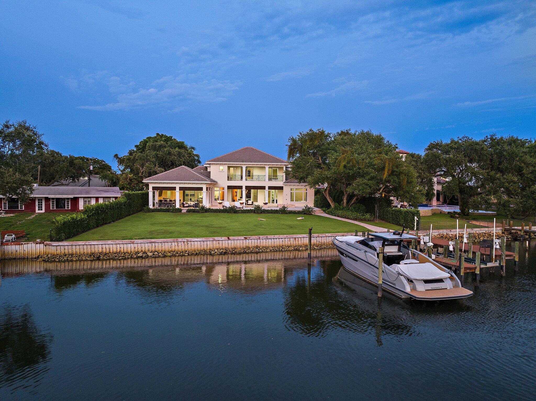 Welcome to your dream waterfront estate! This exquisite 5-bedroom + den, 6.5-bath residence is a masterpiece of luxury and comfort, nestled on over half an acre with 135 feet of direct Intracoastal Waterway frontage. Designed for the discerning homeowner, this property boasts a 4-car garage and a private dock with a 20,000 lb. lift--perfect for the yachting enthusiast, offering easy ocean access with no fixed bridges. Step inside to discover a chef's paradise in the gourmet kitchen, featuring a gas cooktop, expansive countertops, dual sinks, and a wine cooler, all adjacent to a cozy casual dining area. For more formal occasions, the elegant dining room awaits. The home also includes a family room and a formal living room, providing ample space for entertaining. Plus, there's a wine room. The first-floor master suite is a sanctuary, complete with his-and-hers closets, a breakfast bar, an office, and a lavish en-suite bathroom. Each of the remaining bedrooms also features its own en-suite bath, ensuring privacy and comfort for all.
Additional highlights include a second-floor loft, an exercise room, and a workshop in the garage. Outdoor living is elevated with a covered lanai, summer kitchen, and a stunning pool and spa, all overlooking the Intracoastal Waterway. The large backyard leads to your private dock, where you can enjoy the best of waterfront living. This home is equipped with a 48 KW whole-house generator and exudes timeless Old Florida style. Don't miss this rare opportunity to own a piece of paradise!