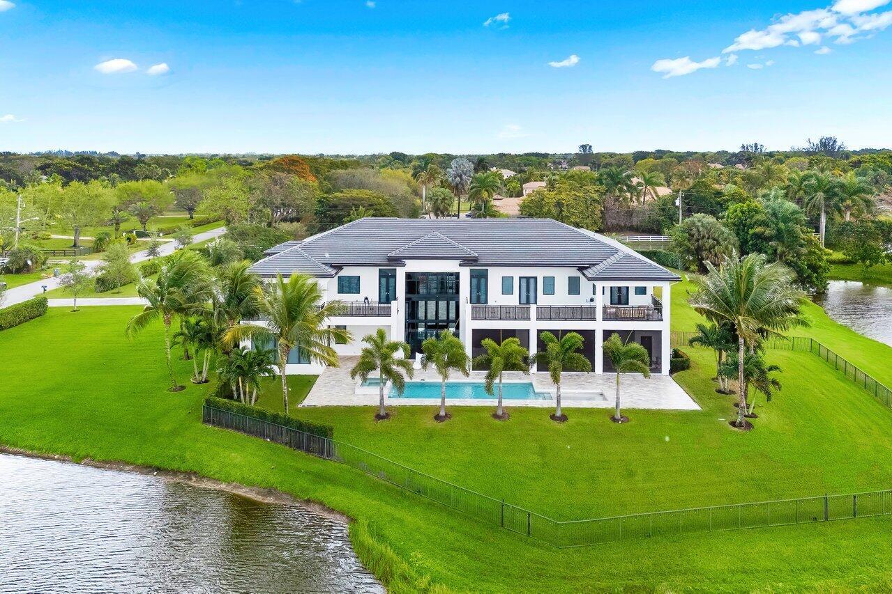 This true estate on 5.66 acres features dramatic lakefront views within the private gated community of only 78 homes.  As a transitionally modern designed residence, it features a two story main entry, foyer and main living room, with soaring floor to ceiling glass windows.  A billiard area, family/ media area, dual island full kitchen, bar area, a primary suite with dual bathrooms and secondary bedroom suite complete the first floor level interior. A 45 foot covered patio with winter kitchen, an open heated pool with spa complete the exterior.  The secondary level consists of four full bedroom suites, three of which open to spacious open and covered patios, and a media/ club room. A grand circular driveway, four car garage and lush landscaping offer total privacy.  See MORE ... Additional downstairs bedroom as well as upstairs and downstairs laundry rooms. Upstairs bedroom suites have direct access to an expansive patio terrace with French doors. Ideal entertaining spaces from the upstairs balconies to the pool, automatic screens and cabana bath. Yard is fully fenced in with mature landscaping hedge along the property line. House features all impact windows and a Kohler generator. 

Additional House Details: 
Driveway - gray paver circular
4 car garage plus
5.6 acres
Concrete tile
Waterfrontage
Mature landscaping
Fenced in
Impact windows - full
Built in sound speakers
Private
Septic - county water
A/C - 4
2 propane tanks
Kohler generator

Pool: 35 x 12
With sun shelf 7 x 10
Gas heater
Aqua link
Jandy pool heater
Pool and spa air blower
Spa 6 x 5
4 patio uplighting
Cabana bath
Shower
Patio
Tumbled marble floor
Automated screened in patio
Ruby series gas grill
Outdoor kitchen - summer
Pool sun shelf

Foyer: 
Glass front door
Floor to ceiling glass
25 ft high covered entrance veranda

Great room 18 x 20
30 ft ceiling
Floor to ceiling glass
Porcelain flooring 30 x 30
Fireplace - gas, ventless
Powder room
Storage closets throughout.
Staircase stainless steel railings
Wood steps

Primary suite: 25 x 20
Hardwood floors
North and west windows with access to pool patio
Dual walk-in closets with custom built ins
Walk in closet 25 x 14
Dual primary bathrooms
1st bathroom 13 x 13
2nd bathroom 12 x 7
Porcelain floors
Frameless shower
Separate tub
Water closet
Vanity
Sitting area

Billard area
Dining room 14 x 15
Family room 21 x 22
Overlooking pool area
Kitchen 13 x 21
Quartz counter top - waterfall
Dual islands
Under counter storage
Thermador gas 6 burner and grill
Wall oven
Bosch coffee maker
Wood veneer cabinets
Poly textured cabinets
Walk in pantry - with build out custom 8 x 10
Thermador wall microwave
Thermador Beverage drawer refrigerator
Thermador

Guest room suite 16 x 14
With walk in closet and custom closet
Ground floor

Laundry room - upstairs and downstairs
Samsung washer and dryer
Sink and marble countertops
Cabinets

Upstairs powder bathroom
Upstairs - 2nd floor
Access to balcony - open and covered
Hardwood floors throughout
North side balcony with access

Media room -office
VIP Suite 17 x 14
VIP Suite bathroom 15 x 9
Bedroom #3 21 x 17
Bedroom #2 20 x 16
With access to balcony
Lot size 345 x 715 x 340 x 715