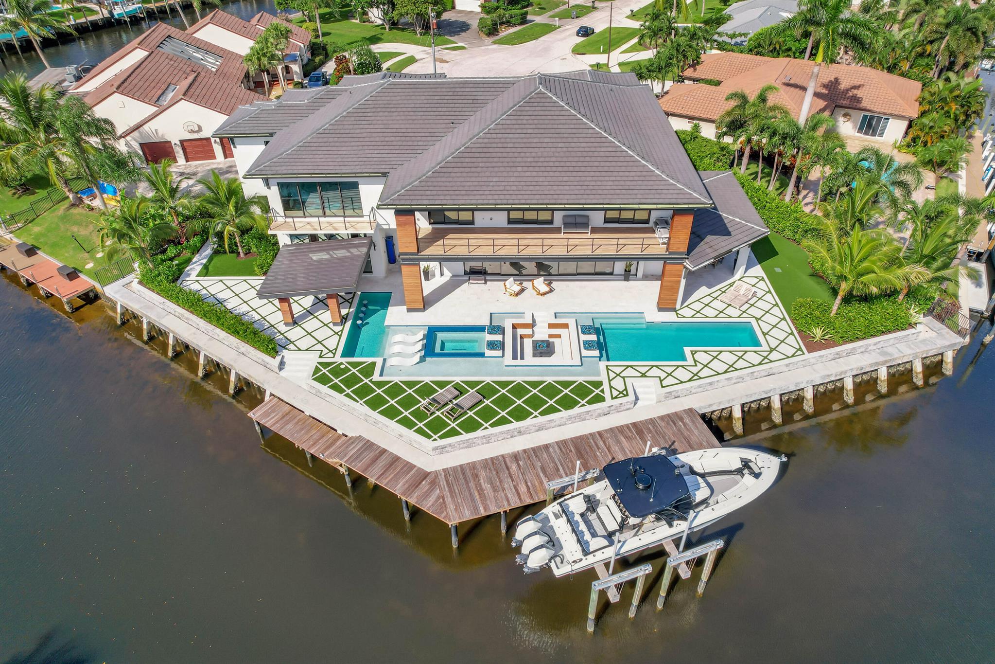 This stunning 2023 waterfront residence offers direct access to the Intracoastal Waterway in the heart of the Palm Beaches. Featuring 6 en suite bedrooms, including 3 primary suites that can flex as a den, game room, or office, plus a golf simulator, two laundry rooms, and a four-car garage. Outdoors, enjoy 188 feet of wide water frontage with a waterfall, sunken fire pit, and a saltwater pool and spa. With ample covered patio space, this home is perfect for entertaining and embodies the essence of Florida living. Close to top restaurants, beaches, and the airport.