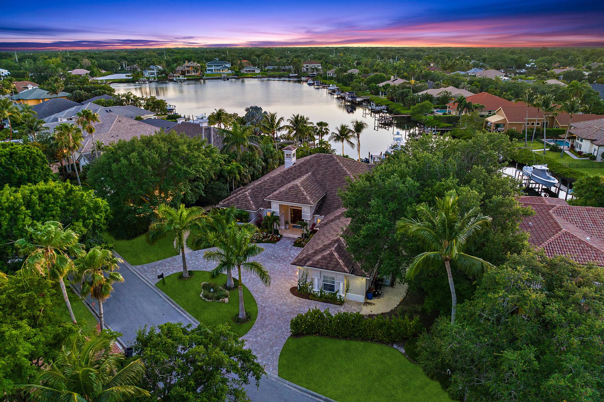 A boater's and entertainer's dream! Experience waterfront luxury living with over 100 feet of Loxahatchee River waterfront! This stunning 4,336 sq ft home, situated on .68 acres, is dramatically updated inside and out. Open the front door into an expansive living room, overlooking a beautiful outdoor living area, complete with a custom pool/spa, expanded outdoor kitchen, turfed yard and putting green, and a recently rebuilt dock complete with a 40k lb lift. The primary suite features a split bathroom, whirlpool tub and sauna, and newly built out dual walk-in closets. With an updated kitchen, 2020 roof, refreshed guest rooms, and brand new beautiful climate controlled wine storage, this home truly has it all. Ocean/restaurants just a short boat ride away.