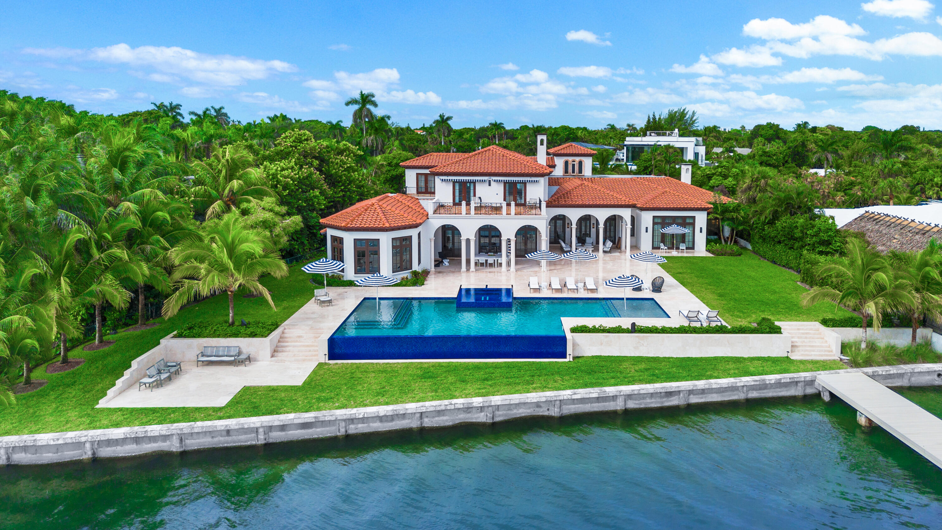 Introducing a remarkable waterfront masterpiece. This ultra-luxury estate spans over 33,000 sq ft of land & 13,000+ sq ft of air-conditioned living space across two stories. Featuring 7 bedrooms & 8.5 baths, the property showcases 140 ft of direct Intracoastal frontage, a private concrete dock, a 60,000-lb boat lift, & a covered jet ski lift. Included is a 2022 Formula 500SSC 50' crossover boat w/ four 600hp engines, plus an 8-car garage housing a 2020 Land Rover HSE & a 2016 Ford Explorer. Enjoy designer furnishings, a commercial-grade gym, & private guest & staff quarters. With no HOA, this is the finest Intracoastal estate available, offering unmatched privacy, luxury, and convenience.