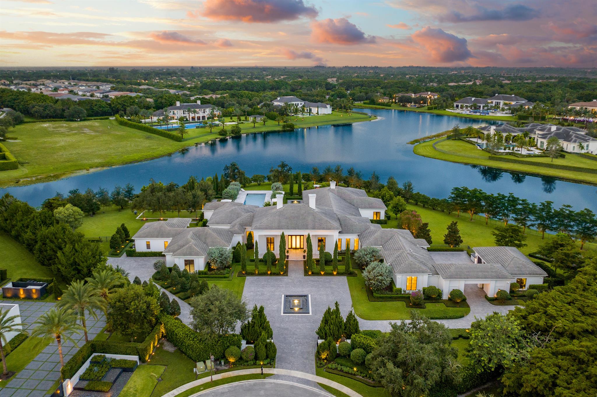 Villa Ananda is an exquisite contemporary masterpiece in Delray Beach, Florida that artfully blends luxury living, technology, and utmost privacy and security. This sublime mansion exudes architectural brilliance, drawing inspiration from the blissful allure of Aman Resorts, emanating an aura of serenity. Brilliantly set behind private gates at Stone Creek Ranch, one of the most exclusive and sought-after communities in South Florida, the sprawling one-story compound boasts a verdant and lush 2.5-acre lakefront setting, with water views from almost every room. The 17,031 SF showcase, with 11,457 SF under air, features a majestic outdoor oasis. Purchased new in 2018, the house underwent a significant addition and extensive ultra-luxury upgrades in 2019. No expense was spared, as a guest wing and additional living space was added. The landscaping, pool, and hardscape were completely reimagined and finishes throughout the house were significantly upgraded.

The perfectly manicured grounds, designed by renowned landscape architect Krent Wieland, offer multiple elements of fire and water making Villa Ananda a one-of-a-kind setting where gracious entertaining comes to life.

An air of serenity permeates the exterior spaces. Italian cypress trees, roses, bougainvillea and Japanese blueberry trees are striking by day and cinematic by night, thanks to perfectly directed landscape lighting and the soothing sounds of water fountains.

Exquisitely curated vignettes unfold in dramatic fashion both inside and outside of this thoughtfully rendered dream home on a quiet cul-de-sac in one of South Florida's most prestigious communities. Villa Ananda encompasses 6 bedroom suites, 7 luxuriously appointed full baths and three elegant powder rooms. The redesign for this meticulously crafted and maintained estate, is by Inson Dubois Wood Interiors, and is cast in soft grays and white, brimming with artisanal touches. Stained European white oak flooring sets a custom tone that extends to millwork, wall finishes, and light fixtures, which are designed with healing Selenite crystal to promote positive energy.

A sweeping island counter of Calacatta Crema marble provides a kitchen centerpiece that's ideal for serving and socializing. Luxury appliances including a Sub-Zero refrigerator/freezer, two Wolf ovens and two Bosch dishwashers, add state-of-the-art complements to this gourmet setting.

The primary suite, expanded to include "her" office and an extra sleeping/resting room, offers stirring views of the garden. Both of the spacious walk-in closets have been masterfully crafted to evoke a boutique style setting.

Indeed, the outdoors is an experience unto itself, replete with a covered lanai, fireplace, electric screens and shades, and a built-in grill. A bougainvillea-draped pergola and fire pit add to the enchanting atmosphere.

This smart home boasts Crestron automation, a Sonos music system, state-of-the-art security, fiber optic cable, and UV water and air purification. The club room, with a projector and 150-inch screen, is perfect for entertainment. Impact windows, a full house generator, and lightning protection ensure safety and convenience. A comprehensive house manual is provided for convenience.

Car enthusiasts will delight in the nine air-conditioned garage bays.

This exclusive community includes a 24 hour manned gate and armed roving security.

Live in tranquility and elegance and at this idyllic residence at Villa Ananda at Stone Creek Ranch.

12 miles to Palmetto Park Road in Downtown Boca Raton
12.5 miles to Atlantic Avenue in Downtown Delray Beach
27 miles to Worth Avenue in Palm Beach