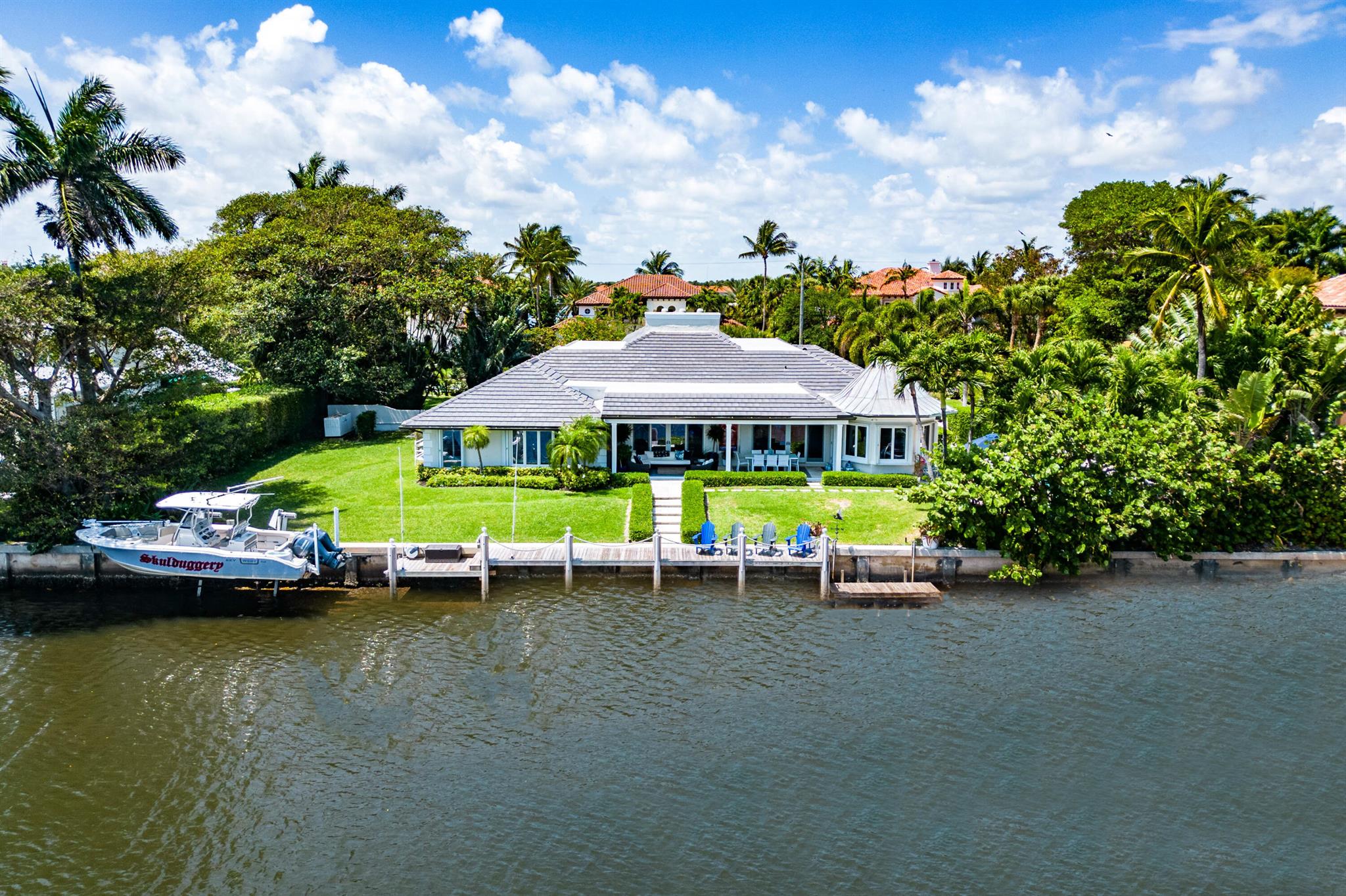 Located in prestigious Pt. Manalapan, this island estate offers 4 Bedrooms/4.5 Bathrooms on an oversized lot (22k+ sq ft). 150 ft of direct water with private boat dock and new lift. Massive grand living room with vaulted ceilings and custom woodwork wall. Gourmet kitchen with large eating nook all overlooking the pool and water, in addition, the dining room, den/movie room all have magnificent water vistas. The split floor-plan offers an oversized primary bedroom suite with huge closets. Three gracious guest suites, all en-suite! The large pool area and covered loggia are perfect for entertaining or relaxing. New Roof and Generator (2022), approved plans for 3 car garage. Whole house Hurricane Shutters, Gratis membership to The LaCoquille Club included with property.