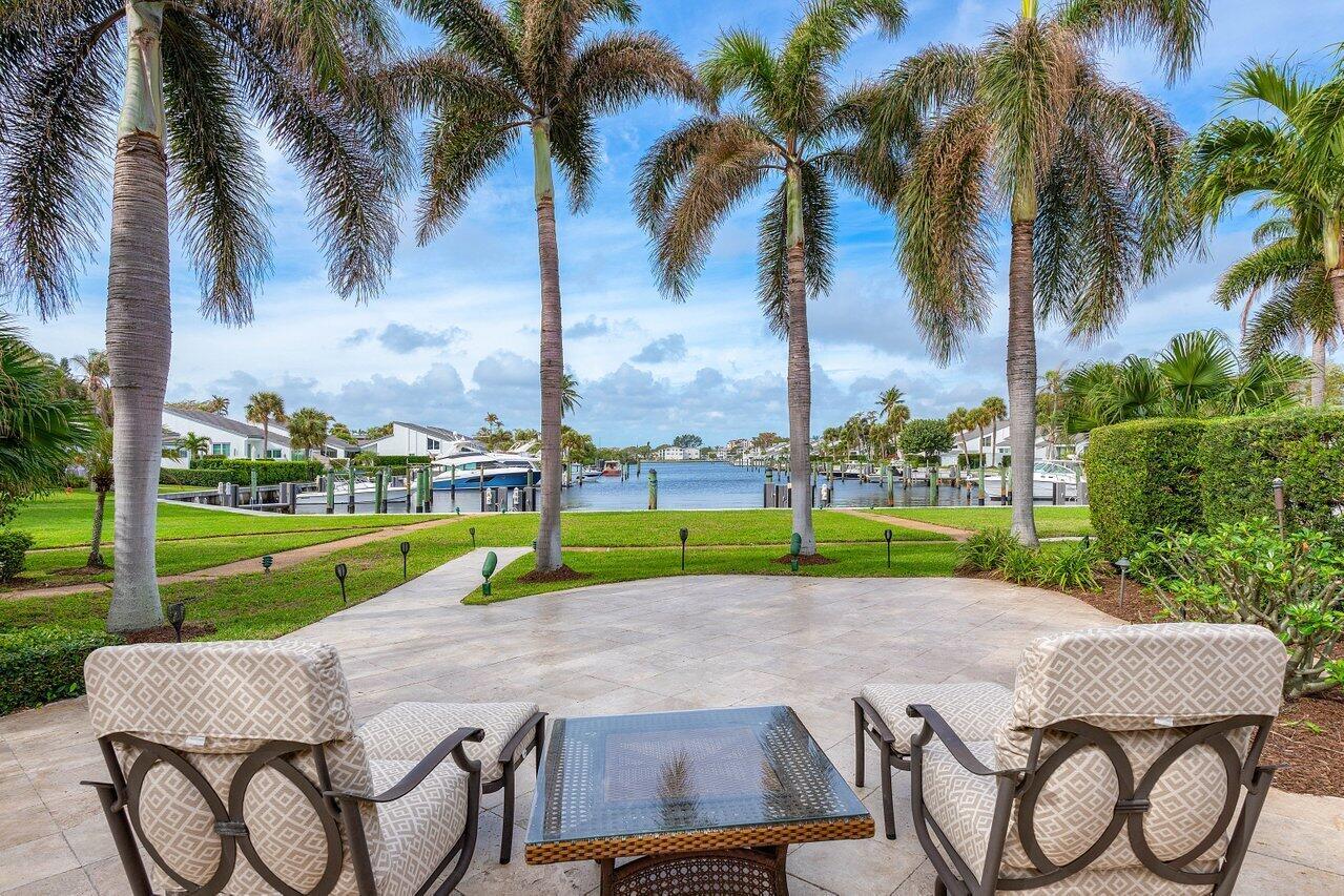 **Boater's Paradise!** If you've dreamed of waterfront living in an exclusive gated boating community just steps from the beach, look no further than this stunning property in Pelican Cove. Nestled in a premier central location in Ocean Ridge, this boutique setting features only 40 homeowners, ensuring a sense of privacy and exclusivity. Overlooking the intercoastal, this home offers breathtaking East-West views, perfect for witnessing spectacular sunsets over the tranquil lagoon. A standout feature is the inviting Florida room, where you can relax and take in the scenic water views, complemented by an impressive extended dock suitable for a 60-foot yacht. Imagine sipping your morning coffee or evening cocktail in this serene environment, surrounded by the soothing sounds of the intercoastal. The dock and the surrounding 2,500-square-foot oasis are adorned with elegant marbled travertine pavers, creating a stylish outdoor space that's perfect for entertaining or unwinding in luxury.