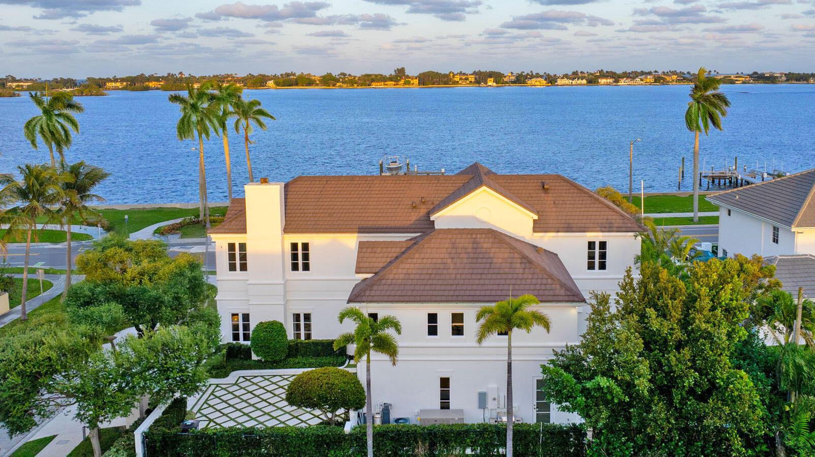 IMPRESSIVE INTRACOASTAL ESTATE INCLUDING ITS OWN PRIVATE DOCK & BOAT LIFT. Newly renovated with every luxury for the discerning buyer, this 5-bed, 4.2-bath home offers breathtaking views of the widest part of the Intracoastal Waterway from all main rooms. Featuring 11-ft ceilings, 6,000 total square feet of meticulously redesigned living space, elevator, and a desirable semi-attached guest house. The very impressive waterfront bar/lounge features LED backlit crystalline quartzite a stunning brass sink, ice maker, and custom cabinetry, all inspired by the Bulgari Hotel in Paris. A sprawling primary suite complete with oversized dual dressing rooms with Italkraft closets and custom cabinetry. This home has an abundance of natural light, high-end finishes, and every conceivable amenity... ...a stunning brass sink, ice maker, and custom cabinetry. This sophisticated 2-story home also includes a guest apartment for extended stays or ultimate privacy. Every element of this home is crafted for luxury living: wine wall, putting green, gated driveway, full house generator, integrated smart home system, and elevator. Perfectly located near Palm Beach Island, PBI Airport, premiere shopping, dining, and more. An adjacent lot is also available for purchase, offering unparalleled potential for expansion. This is a rare opportunity to own one of SoSo's finest estates!!!