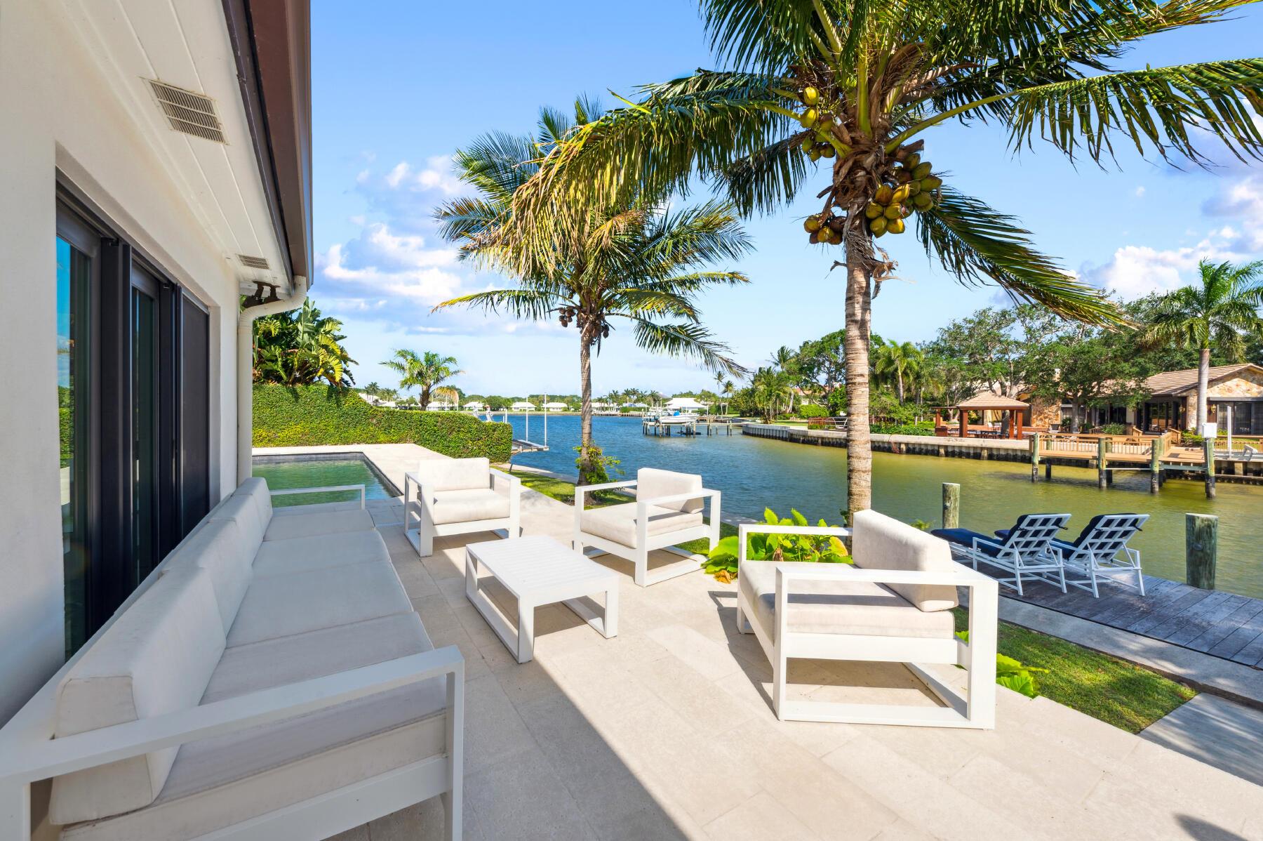 This striking 4-bedroom, 3-bath plus a den, ranch-style waterfront home is in the family-friendly gated community of Hidden Key in North Palm Beach. It is picturesquely placed on the ideal section of a peaceful cul-de-sac w/ 130 feet of water frontage and includes a dock and 14,000-pound boat lift. New owners will enjoy panoramic water views from the kitchen, dining, and family rooms, featuring a wood-burning fireplace. This move-in ready property boasts newly remodeled bathrooms showcasing RH vanities and more. Pet-friendly outdoor space is anchored by a refinished PebbleTec pool, surrounded by a spacious deck. Complete with hurricane windows, 2020 A/C units, and a welcoming coquina walkway, this home embodies luxury coastal living and is a short drive to a top-rated beach. Owner-Agent.