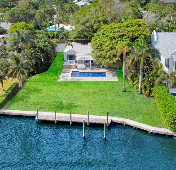 Welcome to this exceptionally rare gem on the exclusive Fisher Lane in the prestigious Palm Trail neighborhood of Delray Beach. Nestled on over a half-acre waterfront lot with 101' of direct intracoastal frontage and 220' of lot depth with private dock, this property offers endless potential for builders, investors, or end-users alike. This unique address of 1 Fisher Lane is perfectly situated on main channel of the intracoastal waterway and on a quiet ''private lane'' with beautiful trees. With only three other homes on this secluded street, you'll experience unparalleled privacy and tranquility. The current residence is outfitted with newly installed impact windows and doors; a renovated, open, modern industrial chef's kitchen; beautiful waterfront Primary Bedroom with ensuite bath; sprawling fenced yard with mature palms, mature Banyan, and lush foliage; resurfaced pool; living room with wood-burning fireplace; and circular driveway. The Primary Bedroom and 1 guest bedroom are located in the Main House and 2 separate 1 bedroom/1 bath guest suites are adjacent to the Main House, both with private entrances and access from separate gate-enclosed courtyards. 

Being less than 1 mile from the endless array of dining, shopping, and entertainment of Atlantic Avenue, this is an opportunity not to be missed!