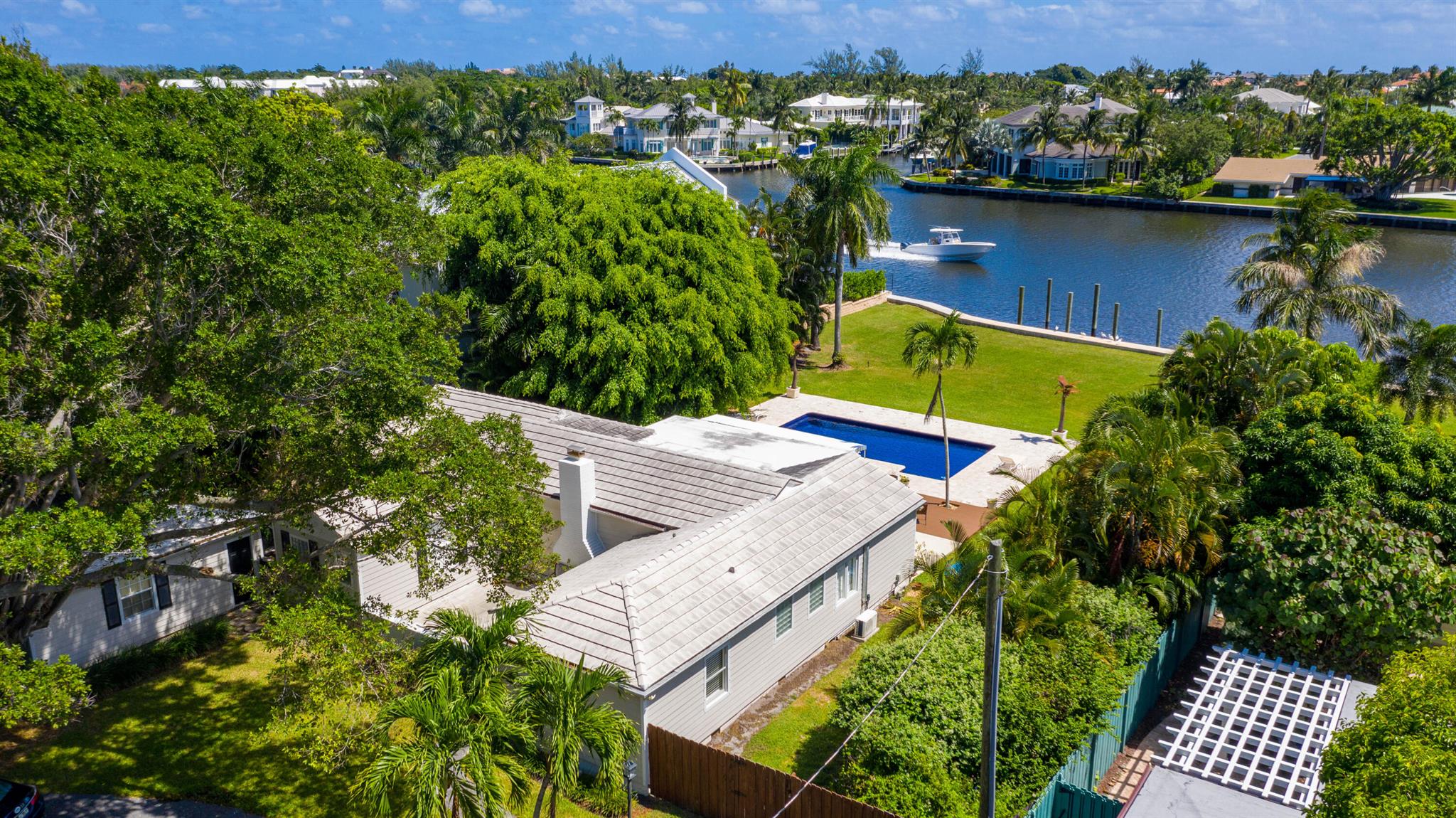 Welcome to this exceptionally rare gem on the exclusive Fisher Lane in the prestigious Palm Trail neighborhood of Delray Beach. Nestled on over a half-acre waterfront lot with 101' of direct intracoastal frontage and 220' of lot depth with private dock, this property offers endless potential for builders, investors, or end-users alike. This unique address of 1 Fisher Lane is perfectly situated on main channel of the intracoastal waterway and on a quiet ''private lane'' with beautiful trees. With only three other homes on this secluded street, you'll experience unparalleled privacy and tranquility. The current residence is outfitted with newly installed impact windows and doors; a renovated, open, modern industrial chef's kitchen; beautiful waterfront Primary Bedroom with ensuite bath; sprawling fenced yard with mature palms, mature Banyan, and lush foliage; resurfaced pool; living room with wood-burning fireplace; and circular driveway. The Primary Bedroom and 1 guest bedroom are located in the Main House and 2 separate 1 bedroom/1 bath guest suites are adjacent to the Main House, both with private entrances and access from separate gate-enclosed courtyards. 

Being less than 1 mile from the endless array of dining, shopping, and entertainment of Atlantic Avenue, this is an opportunity not to be missed!