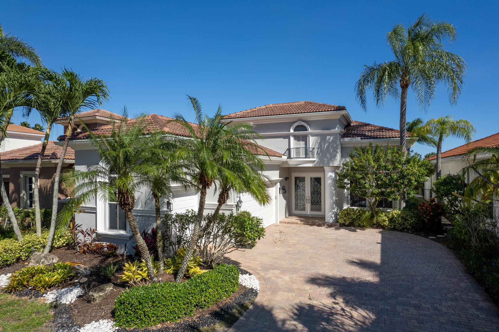 Enjoy the golf view from this stunning home situated on the first hole of the Jack Nicklaus-designed Tradition Golf Course. The 3BR/3BA home is in the highly sought after neighborhood of Via Villagio. This home boasts dramatic architecture, extensive crown molding, coffered ceilings, and an open feel from the moment you enter. The wonderfully renovated kitchen offers custom white wood cabinetry, Quartz countertops, upgraded designer hardware and backsplash, and upgraded stainless GE appliance package. New custom floor-to-ceiling built-in feature wall in the family room to add to the architecture with beautiful ledger stone and new LED fireplace. Enjoy the magnificent travertine pool deck and stunning pool and spa. There is generous space for outdoor dining, sunbathing, and relaxation. Accordion storm shutters protect the exterior of this home. The spacious primary suite with sitting area also features access to the outdoor screened area, floor to ceiling windows and 2 walk-in closets with build-ins for ample storage. The primary bath has been completely renovated with new marble flooring and new hydro shower complete with body jets, rain head and frameless floor-to-ceiling shower door, new vanities, Toto toilet in private water closet, and custom solid teak wood shelving. New LED recessed lighting throughout. All bedrooms are generously sized and ensuite with the 3rd bedroom having new vinyl plank flooring. A brand-new roof in 2024 provides peace of mind. The 2-car garage plus golf cart garage has additional storage. The term "CLOSE TO THE CLUBHOUSE" is an understatement here; a short walk or a quick ride on the cart path (accessed at the end of the cul-de-sac) and you're in the heart of the world class amenities Ibis Golf and Country Club has to offer including: three Jack Nicklaus-designed golf courses, four unique dining experiences, tennis complex, pickleball, fitness center, spa, resort style pool, lap pool and much more.