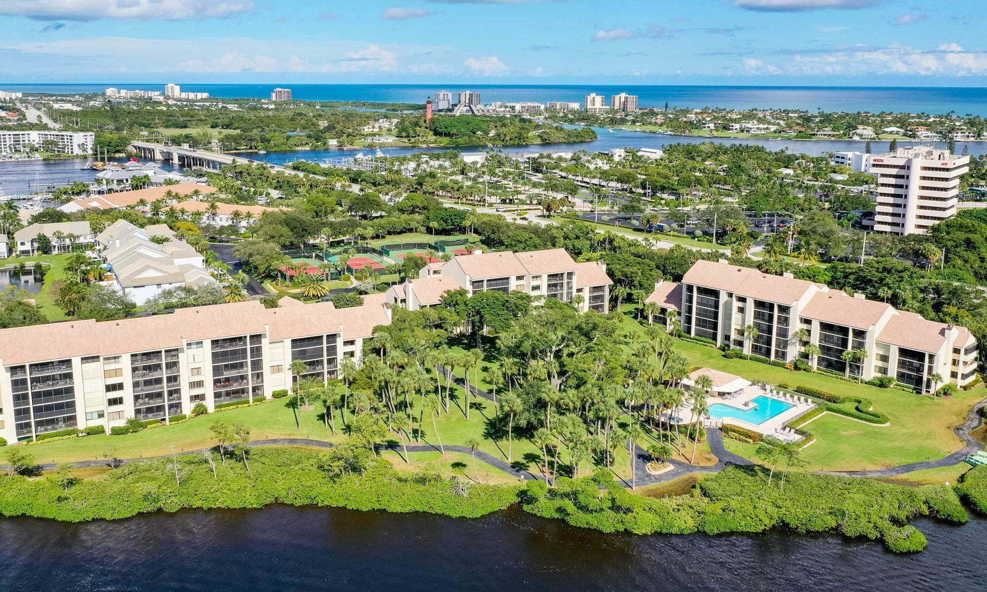 Discover the ultimate in coastal living with this Intracoastal condo in highly desirable Jupiter Harbour. Boasting over 1,400 square feet of air-conditioned living space, this residence offers breathtaking water views that can be enjoyed from the expansive, screened-in lanai. The spacious interior features wood floors, floor-to-ceiling windows that invite an abundance of natural sunlight, cream cabinetry, and a built-in bar for entertaining. Safety and convenience are key with accordion hurricane shutters while the luxury lifestyle is enhanced by Jupiter Harbour's top-notch amenities, incl a 24-hr guard-gated entrance, a resort-style pool, marina, tennis/ pickleball courts, and  paddle board/kayak access for all your water adventures. Don't miss this opportunity to own at a great price!