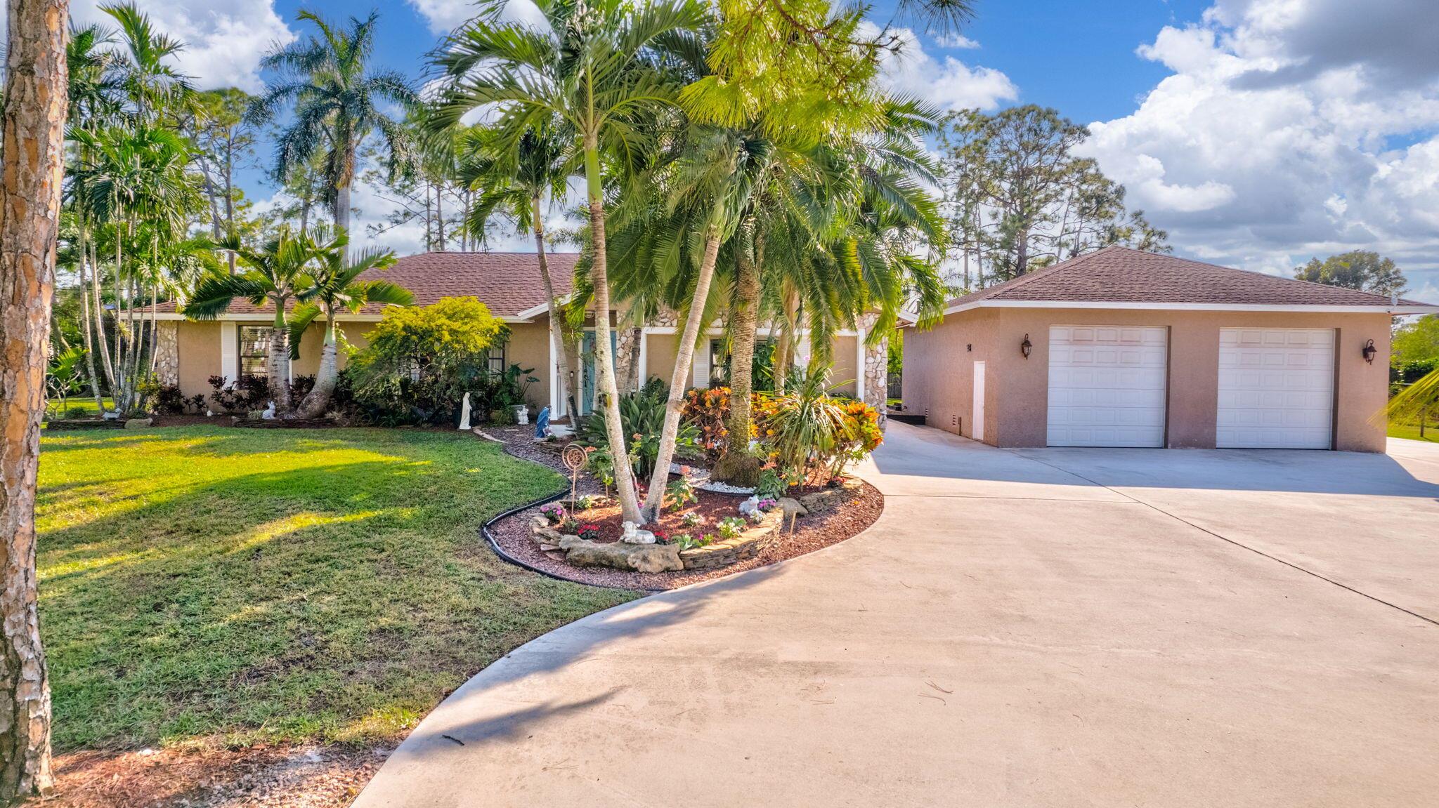 Welcome to this stunning slice of paradise! This beautifully updated 4-bedroom, 2-bathroom pool home in Loxahatchee offers 2,133 sq. ft. of luxurious living space.  The chef's kitchen features sleek stainless steel appliances, custom cabinetry, and granite countertops. With a brand-new air conditioning unit. Step outside to the screened porch, relax by the sparkling pool, and enjoy the lush fruit trees. The expansive 1,300 sq. ft. garage is equipped with built-in workbenches, loft storage, and ample space for hobbies or extra storage. The property also features an RV pad with 30-amp service, a boat dock, a water softening system, and a meticulously landscaped, fully fenced yard on more than 1.37 acres. . Located on a quiet cul-de-sac, this home is the perfect paradise retreat. MUST SEE!