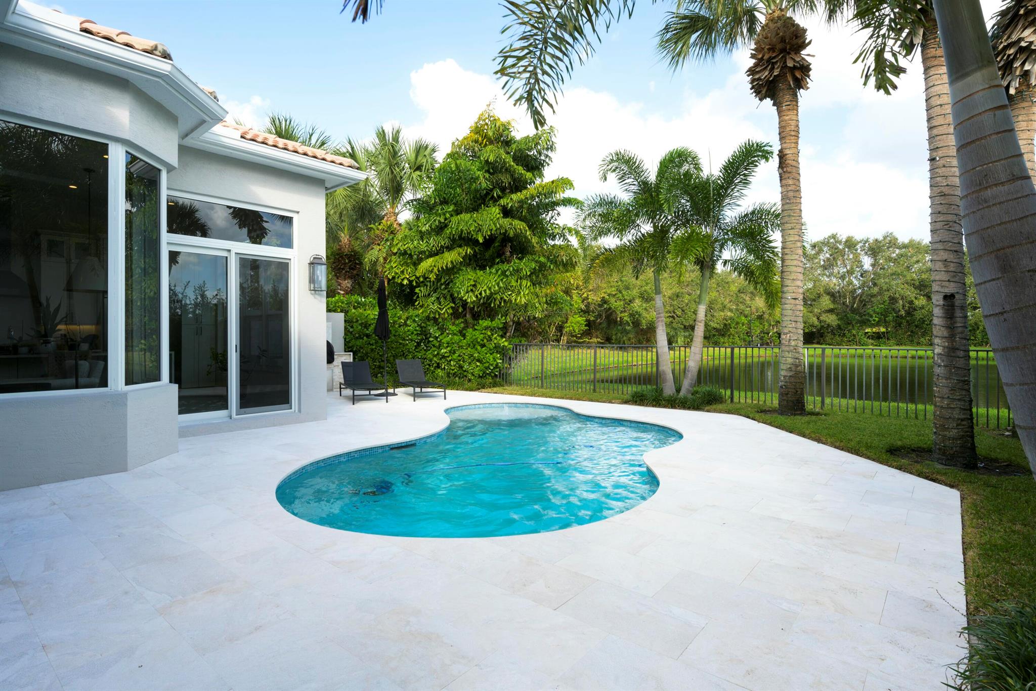 Move right into this four bedroom, remodeled home on the lake. Gorgeous  redone outdoor space, new kitchen with upgraded appliances. New floors, new paint, impact windows, new roof , new A/C  and so much more! Nothing has been left undone! Come home to your piece of paradise!