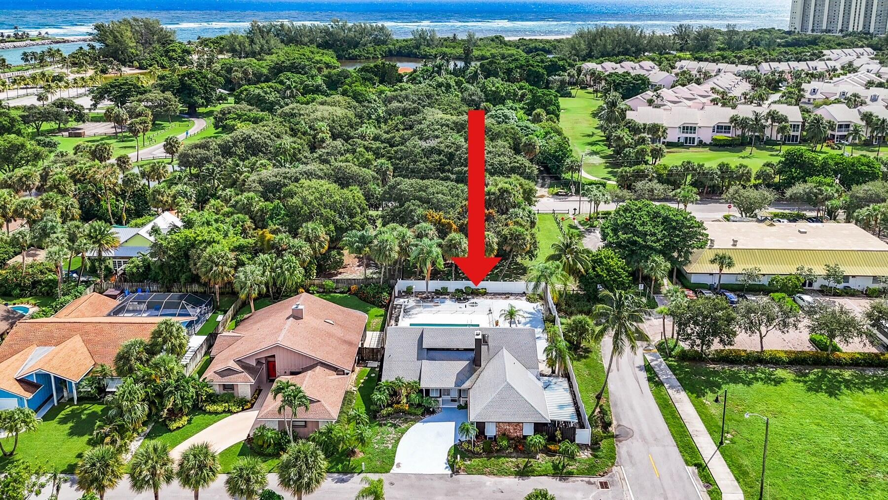 Enjoy your Winter HERE! One of a handful of single family homes nestled in this highly desirable, unique and spectacular Jupiter location. Beautiful, 'Dubois Park', located directly on the scenic inlet is just steps away. Stroll to the beach or to Love Street with it's array of waterfront dining venues and much more... The Lot extends to just under 1/4 of an acre. The split floor plan provides 3 bedrooms, 2 bathrooms, living room with a vaulted ceiling and fireplace, kitchen/dining room, a spacious screened Florida room overlooking the pool. Outside a private pool and tropical, fenced yard with gates to enable parking a boat awaits.